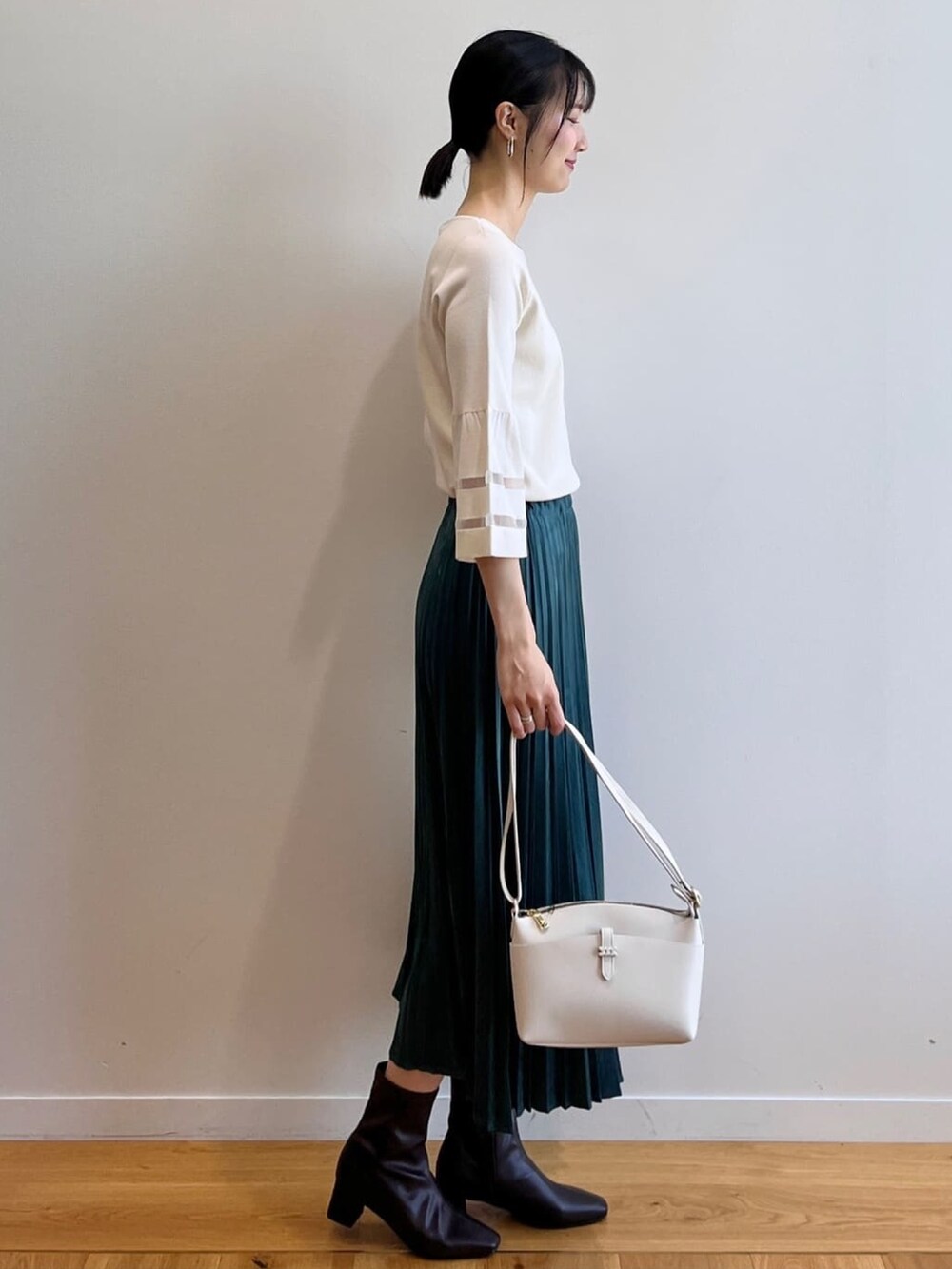 ブラウン系のブーツ、ホワイト系のニット/セーター、ブルー系のスカートを着用したレディースの夏コーディネートの3枚目の写真