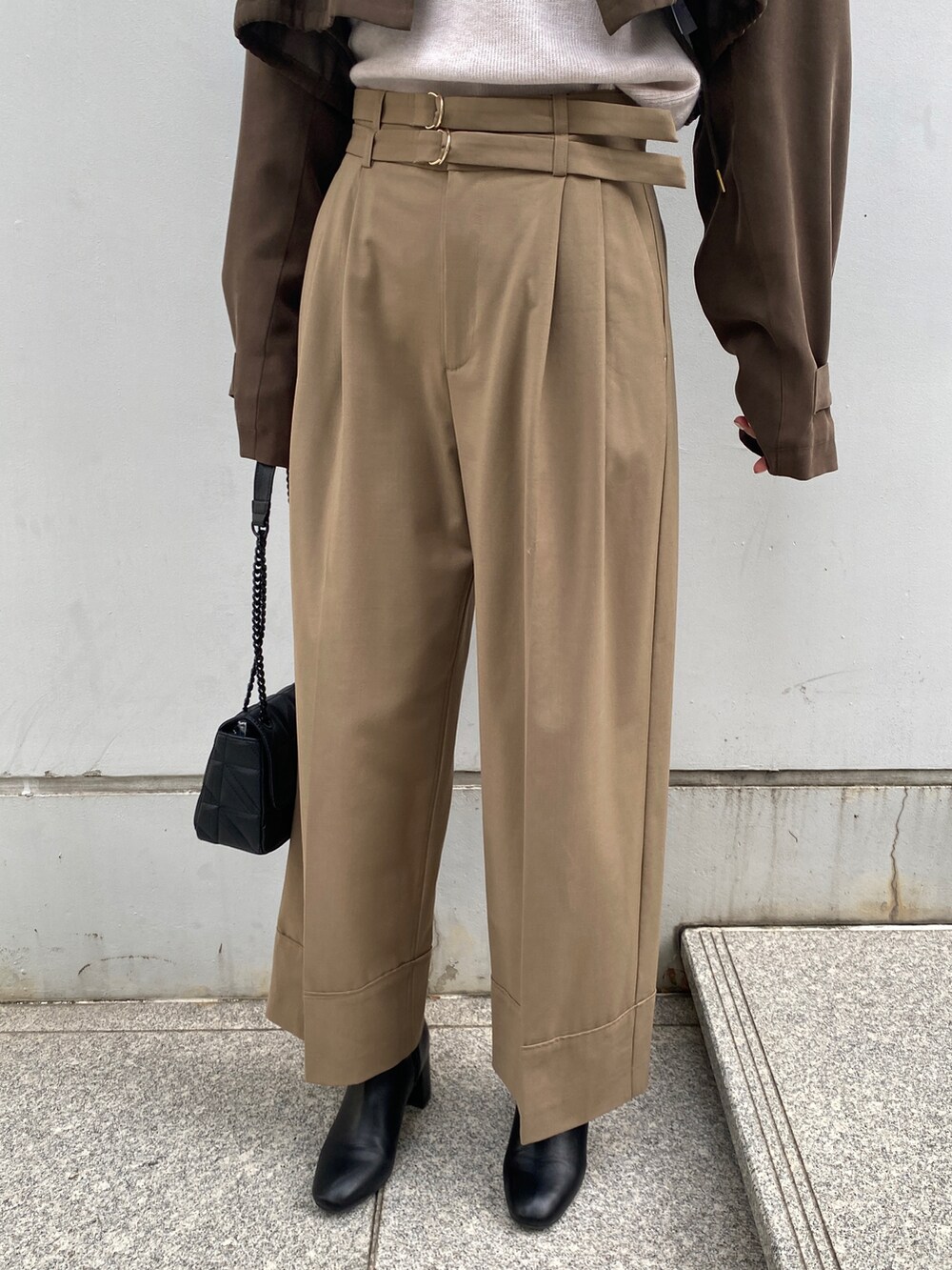 グリーン系のトレンチコート、ベージュ系のその他パンツ、ブラック系のショルダーバッグを着用したレディースの秋コーディネートの5枚目の写真