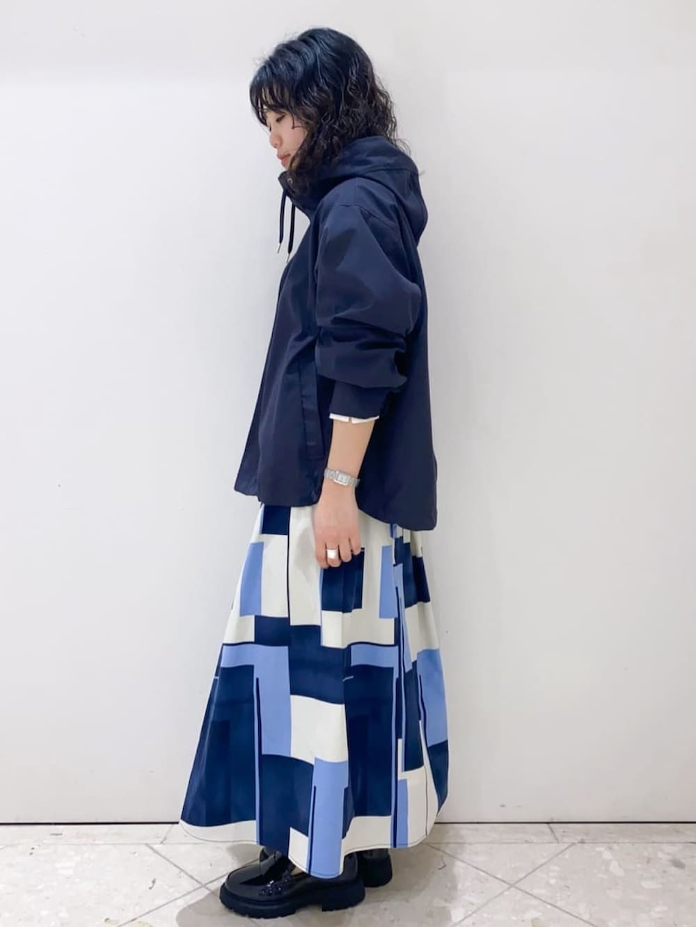 ブルー系のブルゾン、ブルー系のスカート、ホワイト系のニット/セーターを着用したレディースの春コーディネートの2枚目の写真