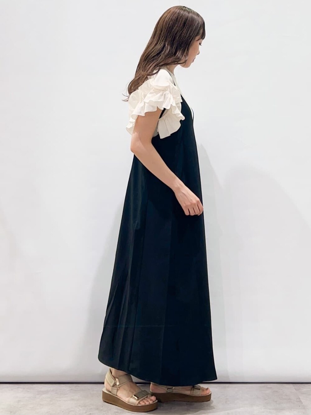 ブラック系のワンピース、ベージュ系のサンダル、ホワイト系のTシャツ/カットソーを着用したレディースの夏コーディネートの3枚目の写真