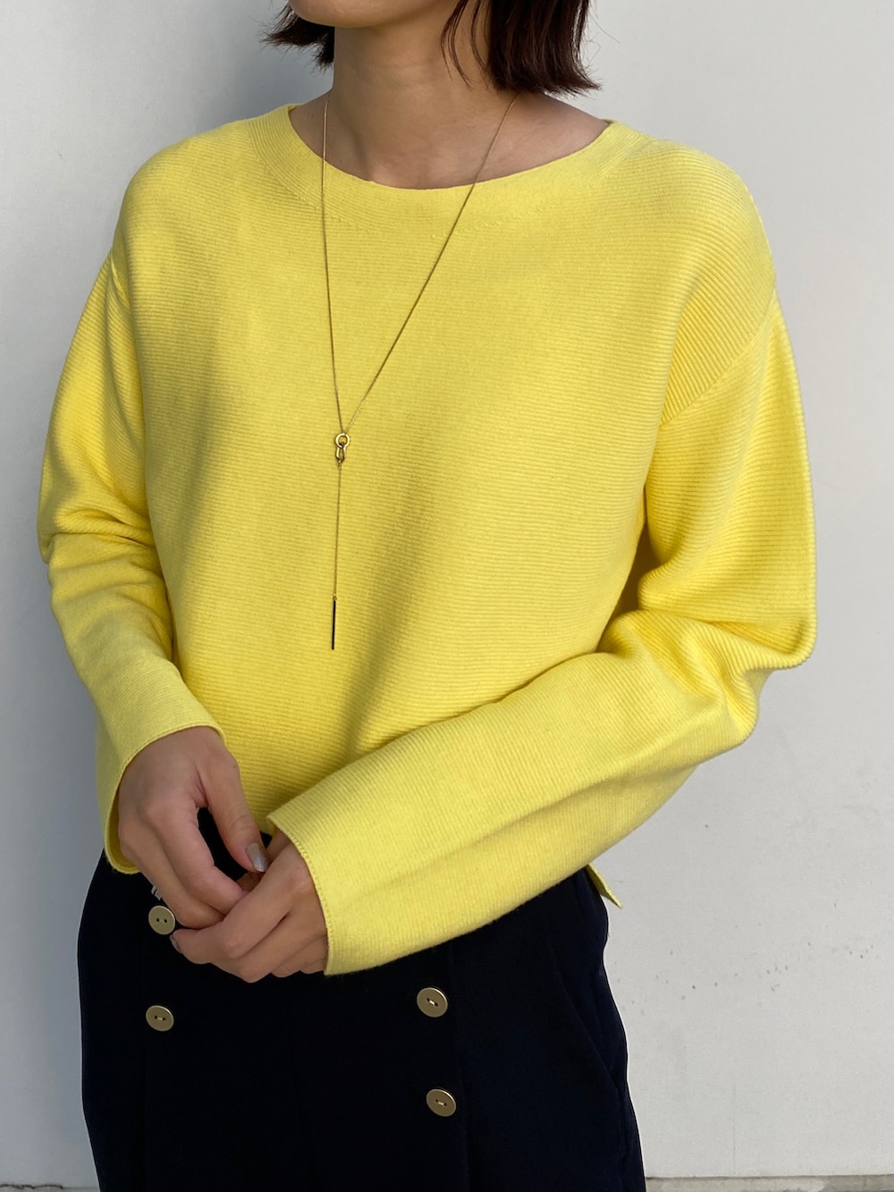 ブルー系のチェスターコート、イエロー系のニット/セーター、ベージュ系のブーツを着用したレディースの冬コーディネートの3枚目の写真