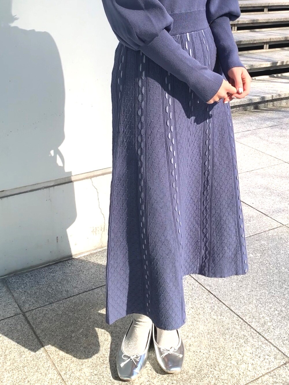 ブルー系のワンピース、ブルー系のショルダーバッグ、シルバー系のドレスシューズを着用したレディースの冬コーディネートの3枚目の写真