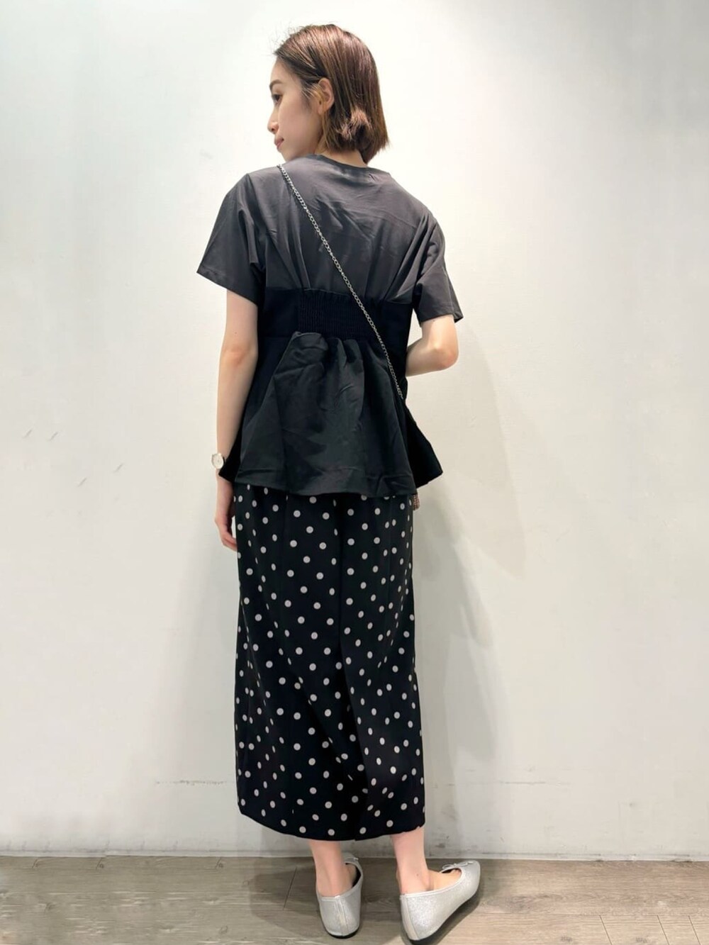 ブラック系のTシャツ/カットソー、シルバー系のパンプス、ブラック系のスカートを着用したレディースの夏コーディネートの3枚目の写真