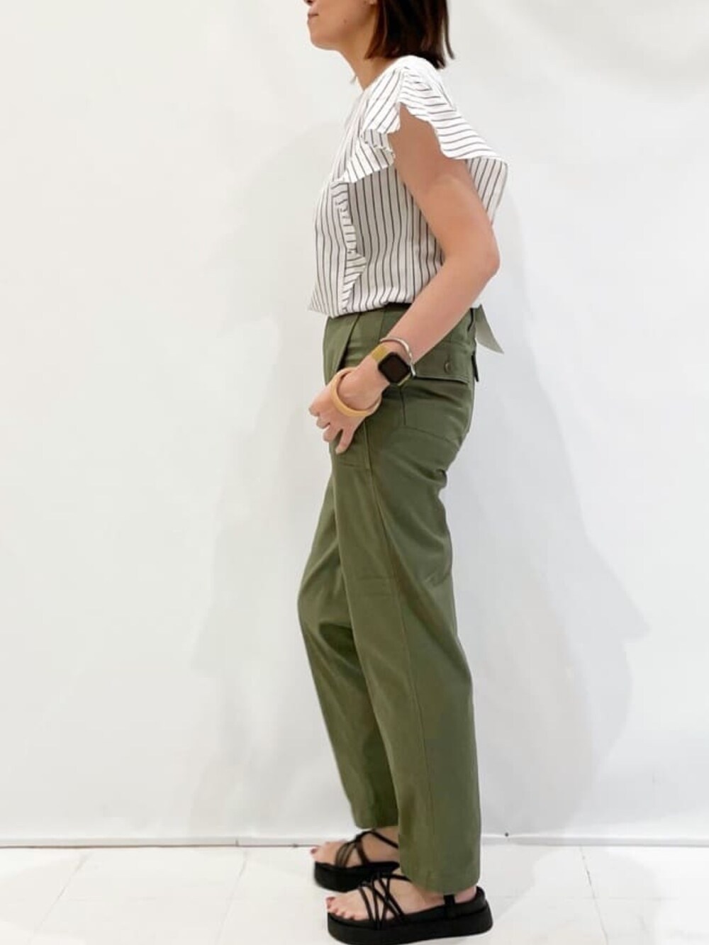 ホワイト系のシャツ/ブラウス、グリーン系のその他パンツ、ブラック系のサンダルを着用したレディースの夏コーディネートの2枚目の写真