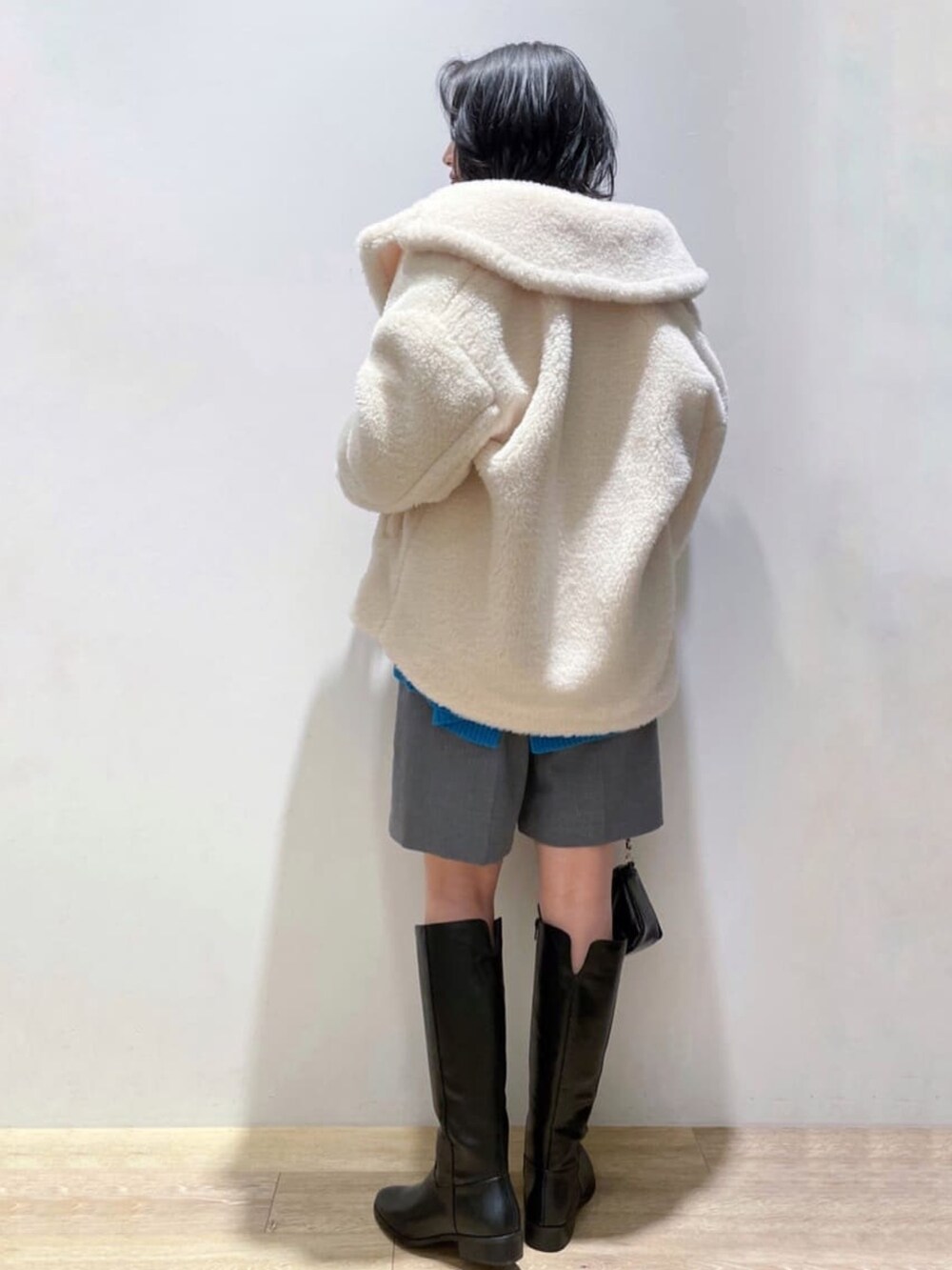 ブルー系のニット/セーター、グレー系のその他パンツ、ブラック系のブーツを着用したレディースの冬コーディネートの4枚目の写真