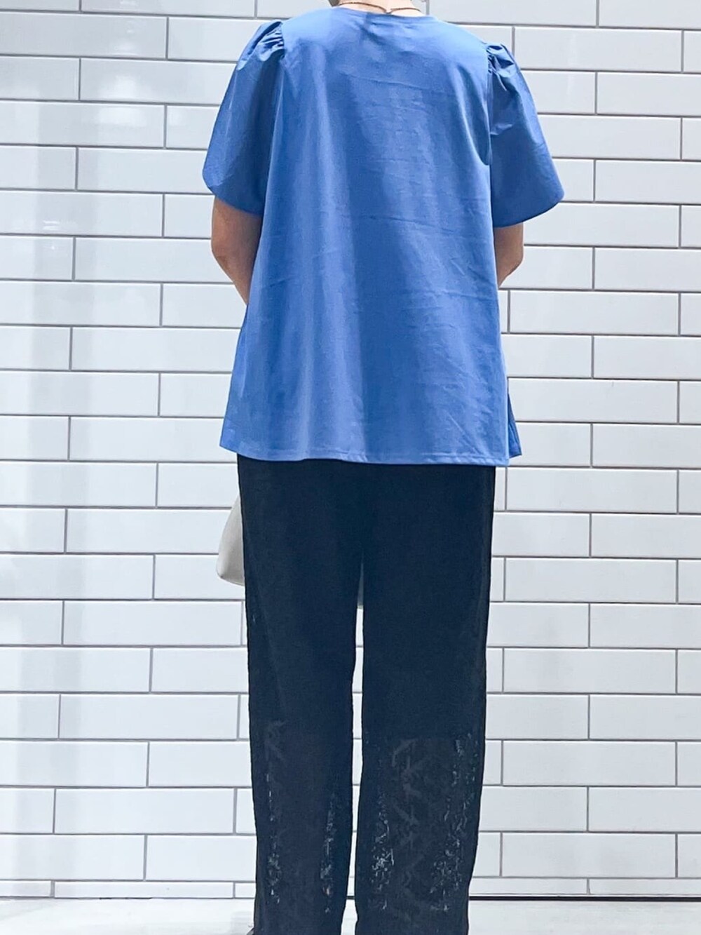 ブルー系のTシャツ/カットソー、ブラック系のサンダル、ホワイト系のショルダーバッグを着用したレディースの春コーディネートの4枚目の写真