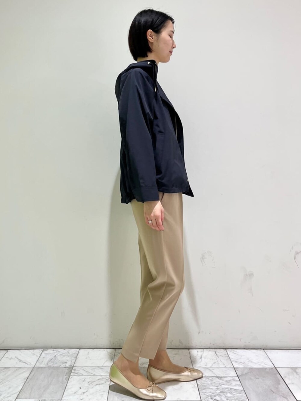 ベージュ系のその他パンツ、ゴールド系のその他シューズ、ホワイト系のニット/セーターを着用したレディースの春コーディネートの2枚目の写真