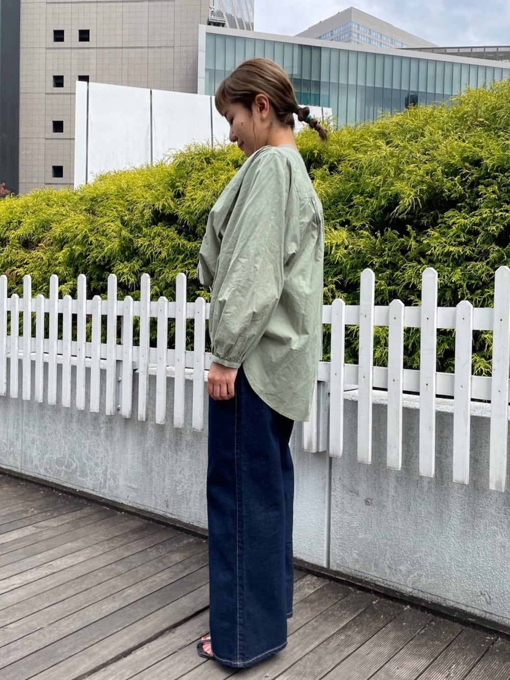 グリーン系のシャツ/ブラウス、ブルー系のデニムパンツ、ブラウン系のショルダーバッグを着用したレディースの春コーディネートの3枚目の写真