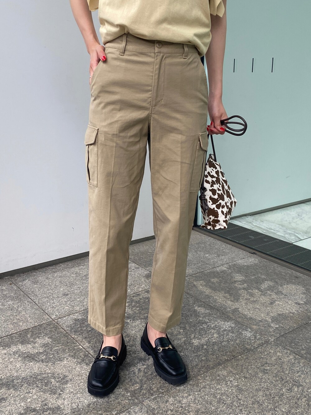 ベージュ系のその他パンツ、ブラウン系のショルダーバッグ、イエロー系のニット/セーターを着用したレディースの夏コーディネートの5枚目の写真