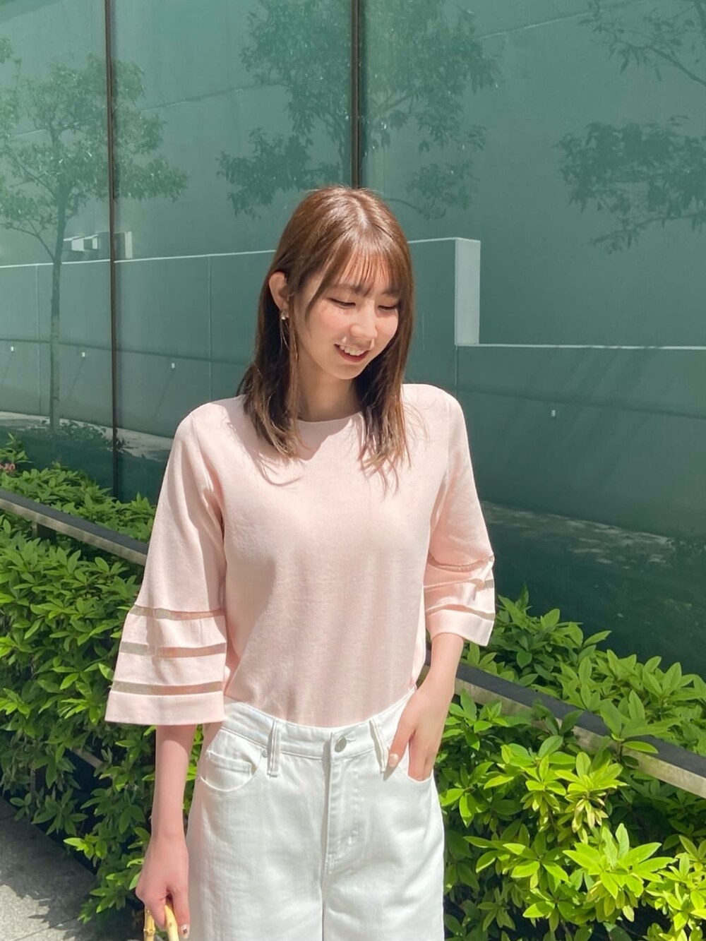 ピンク系のニット/セーター、ホワイト系のデニムパンツ、ホワイト系のサンダルを着用したレディースの春コーディネートの8枚目の写真