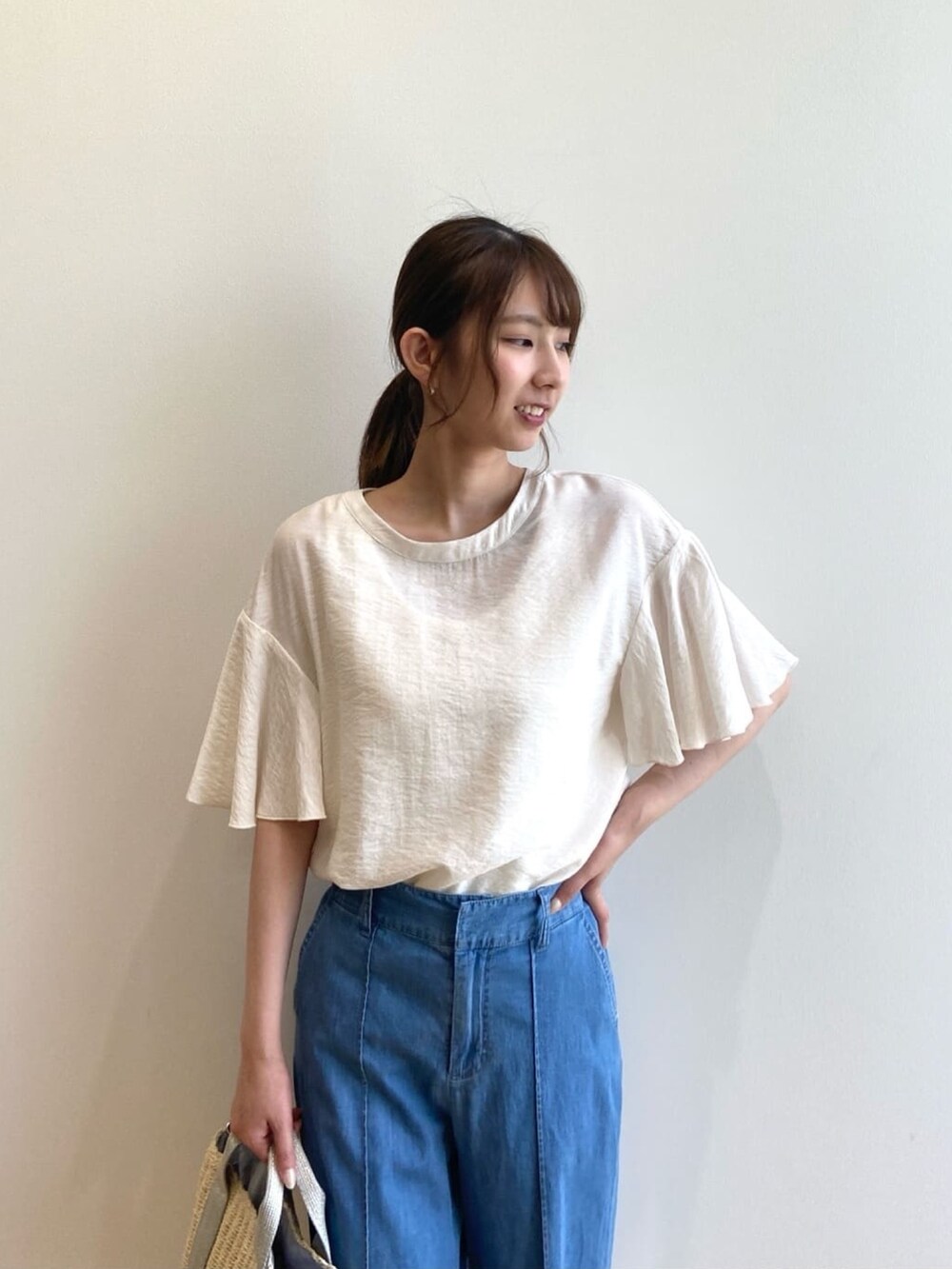 ホワイト系のシャツ/ブラウス、ブルー系のデニムパンツ、シルバー系のショルダーバッグを着用したレディースの夏コーディネートの5枚目の写真