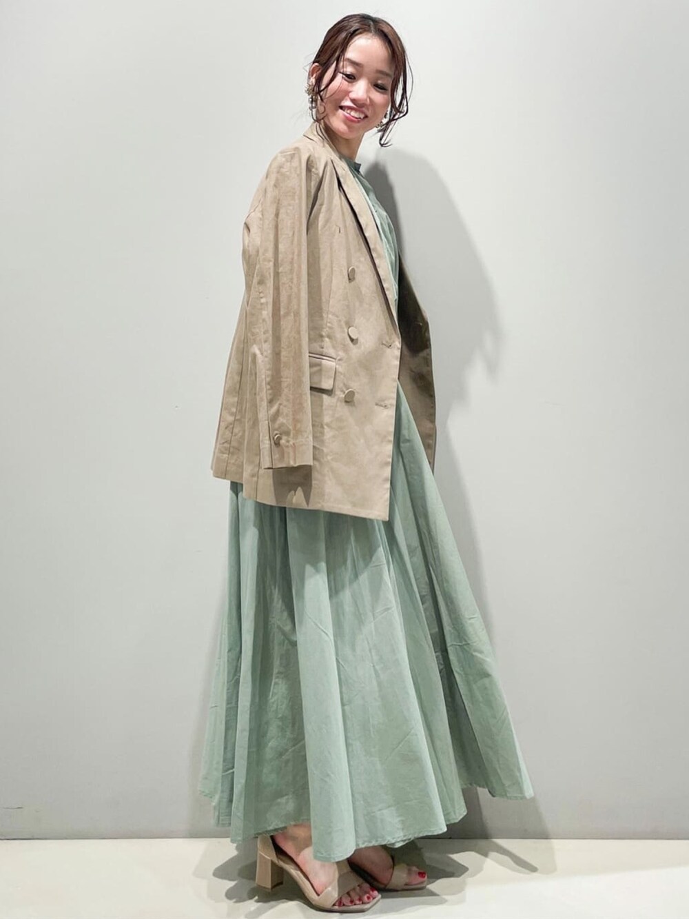 グリーン系のスカート、グリーン系のシャツ/ブラウス、ブラウン系のテーラードジャケットを着用したレディースの春コーディネートの2枚目の写真