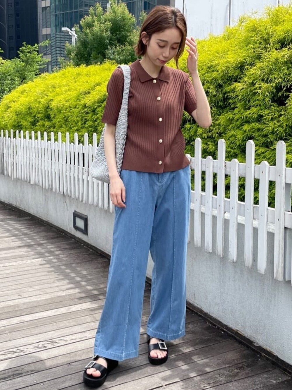 ブラウン系のニット/セーター、ブルー系のデニムパンツ、シルバー系のトートバッグを着用したレディースの春コーディネートの7枚目の写真