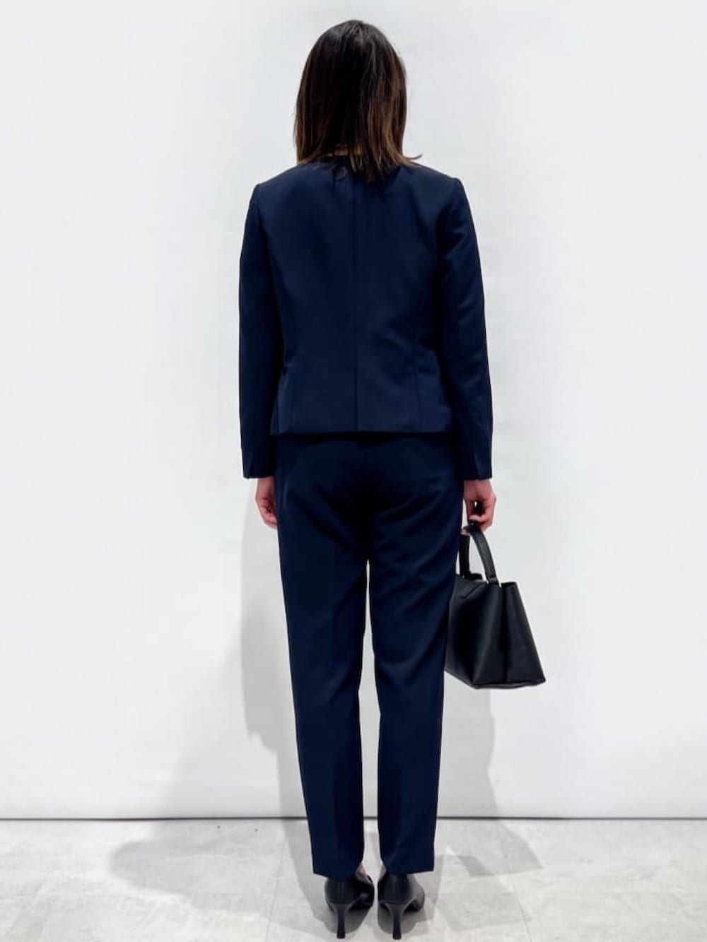 ブルー系のその他パンツ、ブルー系のノーカラージャケット、ブラック系のショルダーバッグを着用したレディースの冬コーディネートの3枚目の写真