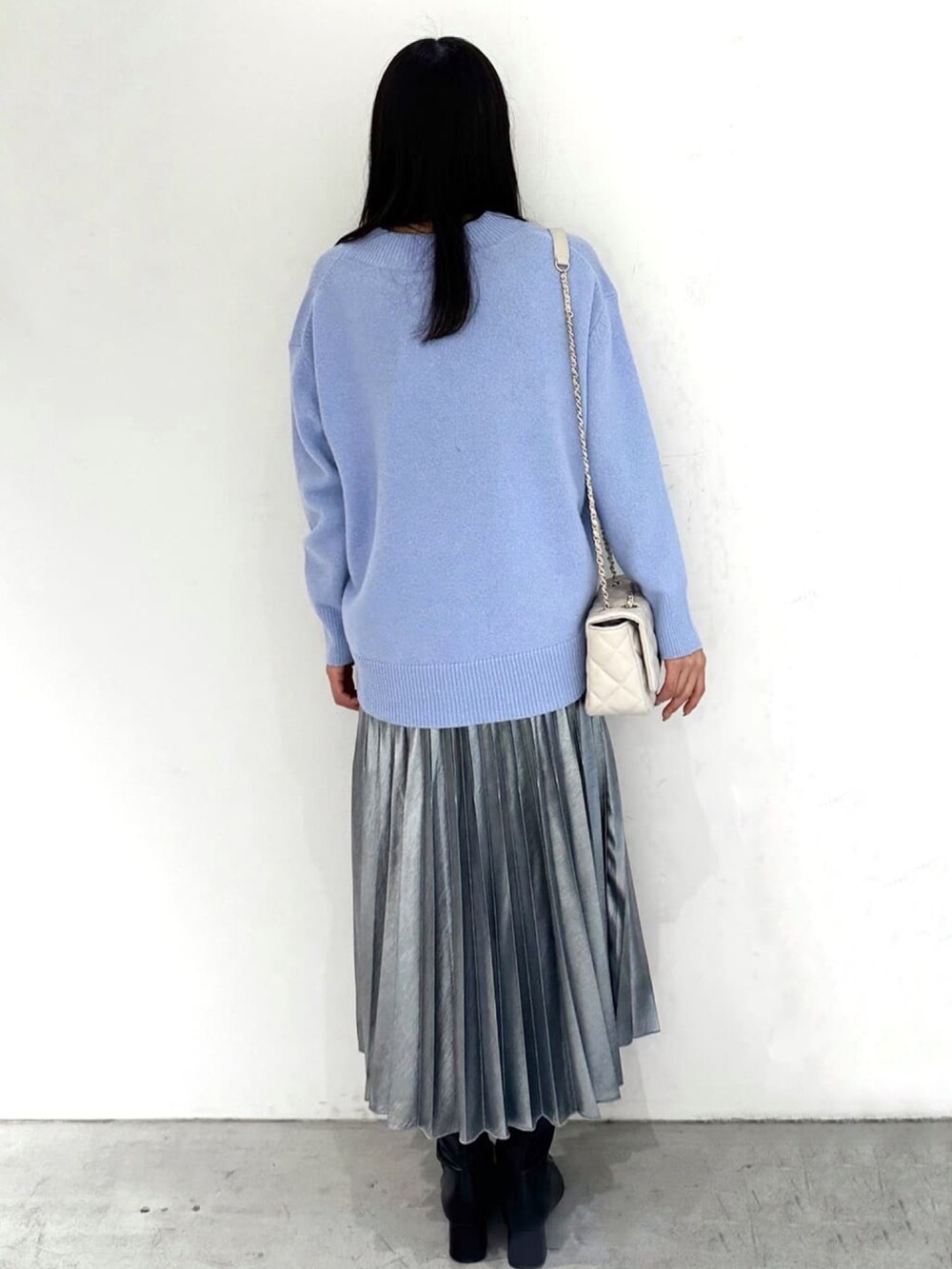 ブルー系のニット/セーター、ブラック系のスカート、ブラック系のブーツを着用したレディースの秋コーディネートの3枚目の写真