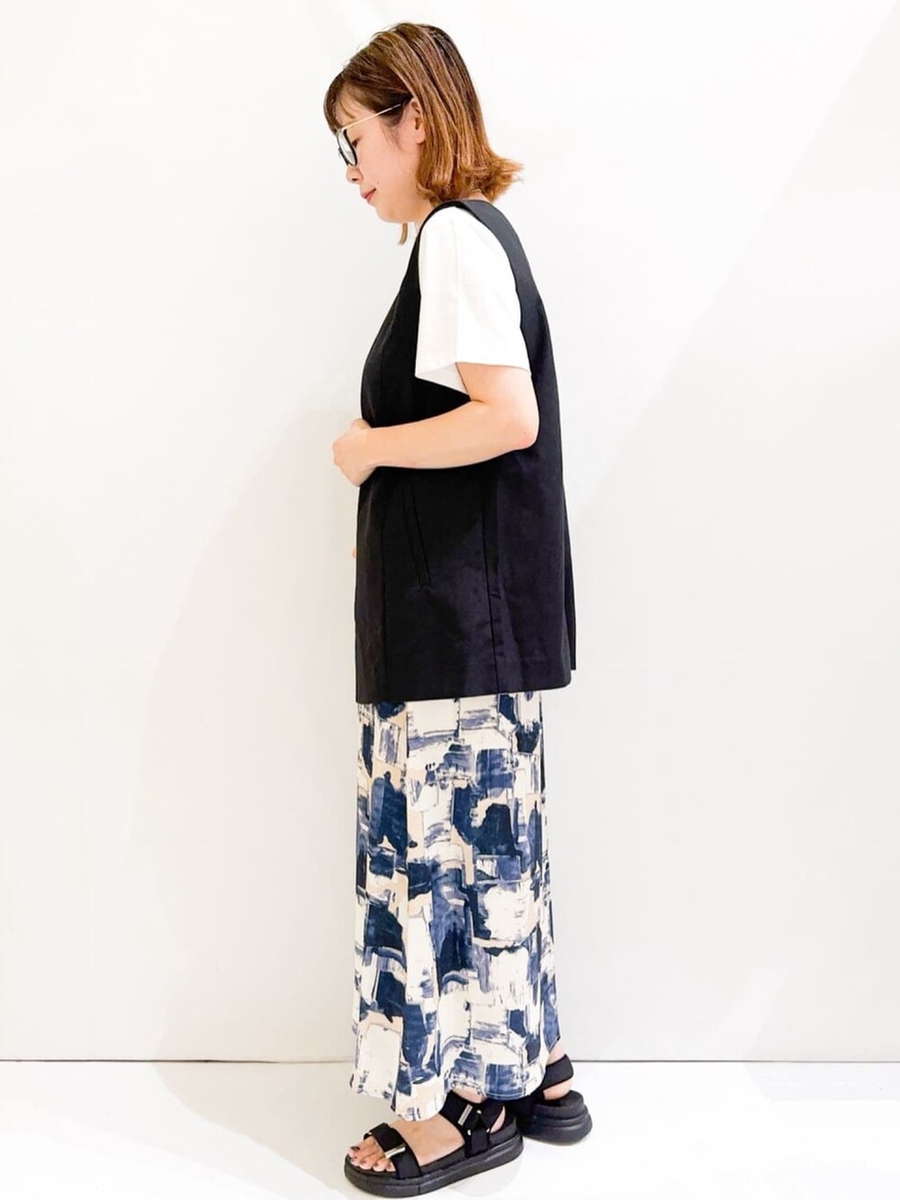 ホワイト系のTシャツ/カットソー、ブラック系のベスト、シルバー系のトートバッグを着用したレディースの夏コーディネートの3枚目の写真