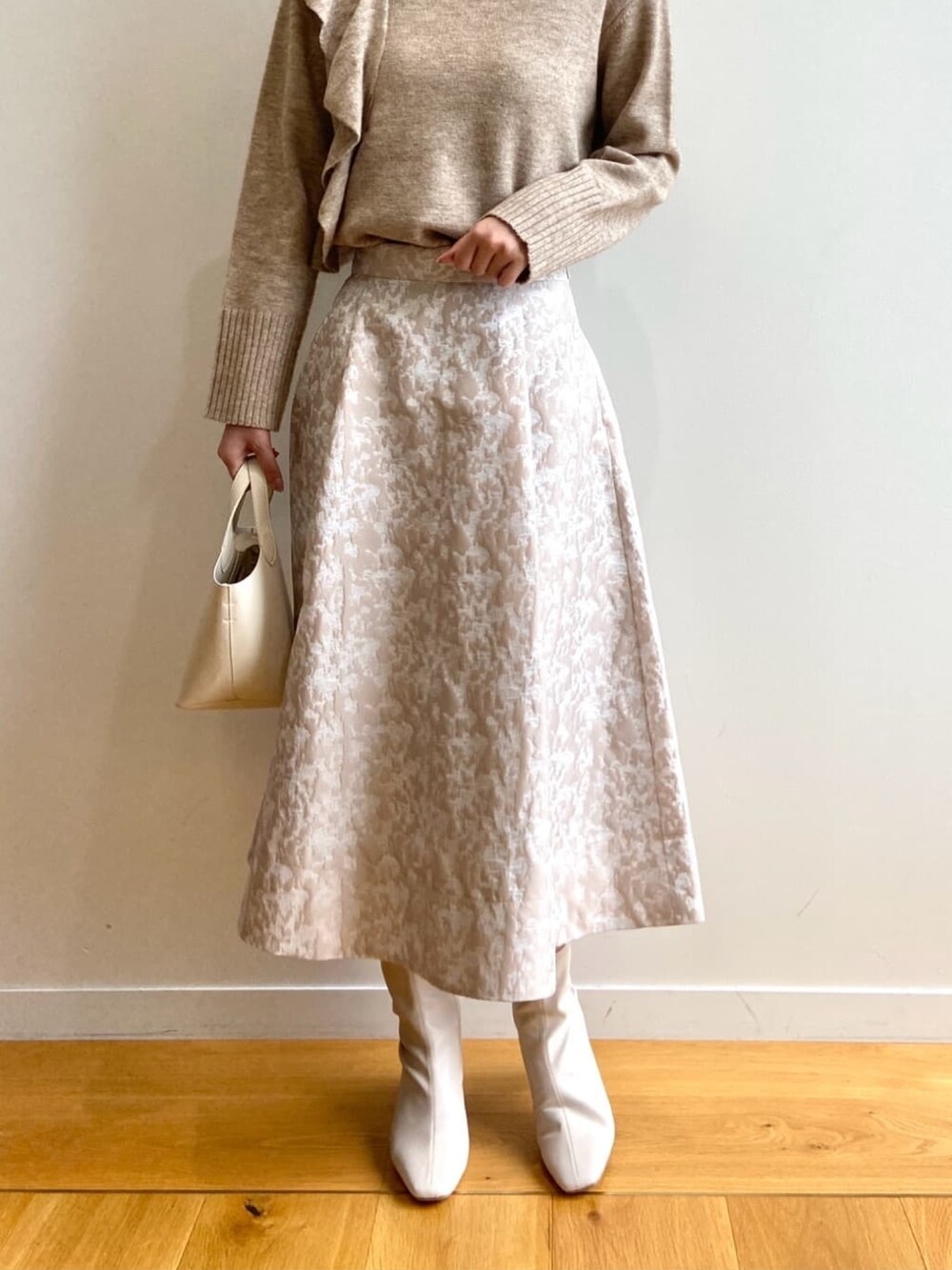 ベージュ系のニット/セーター、ホワイト系のトートバッグ、ベージュ系のスカートを着用したレディースの秋コーディネートの5枚目の写真