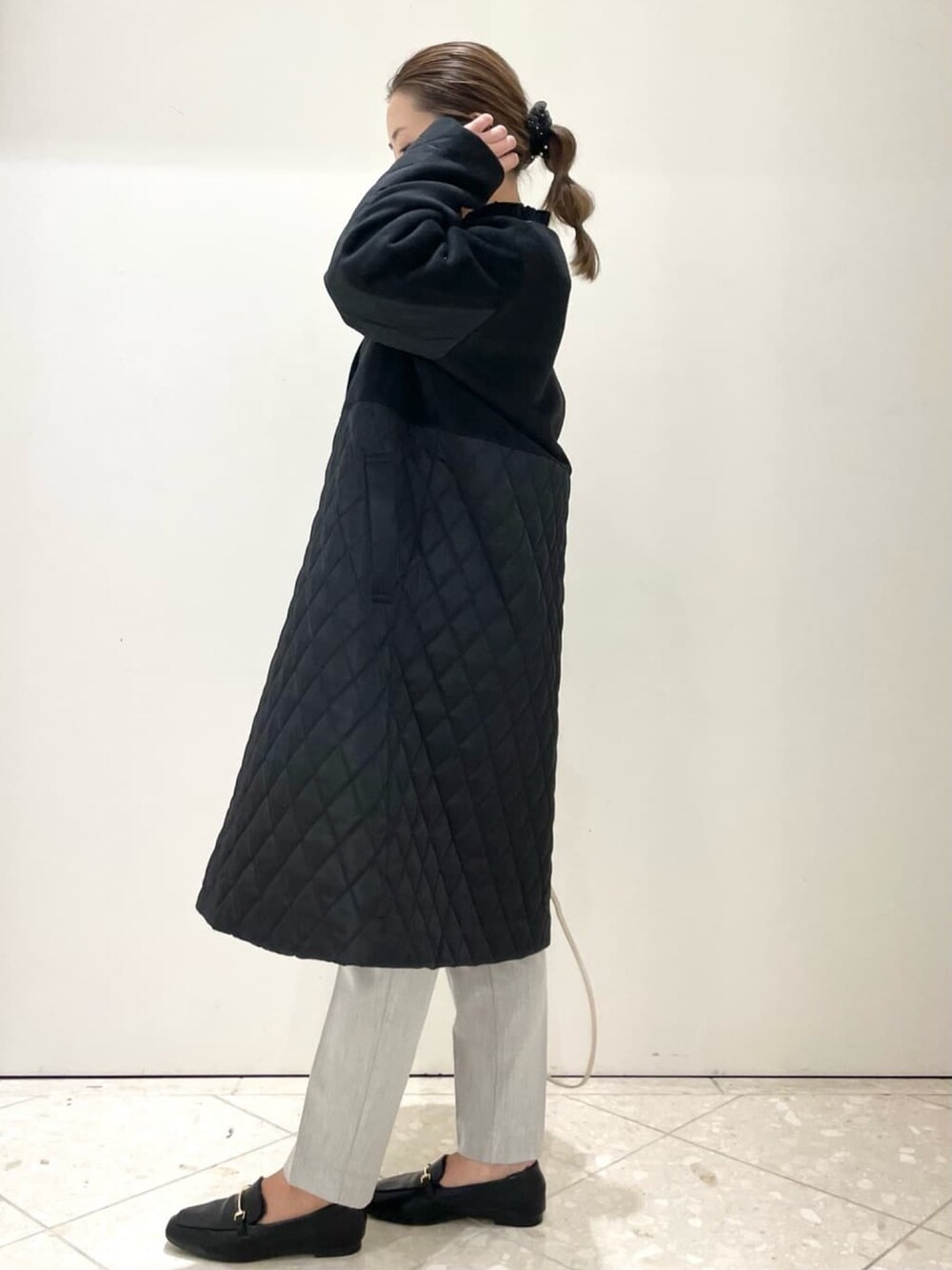 ブラック系のノーカラーコート、グレー系のその他パンツ、ブラック系のパンプスを着用したレディースの冬コーディネートの3枚目の写真