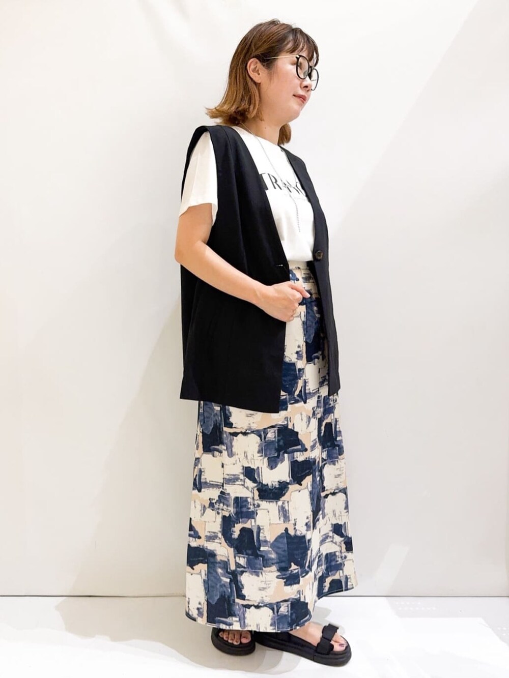 ホワイト系のTシャツ/カットソー、ブラック系のベスト、シルバー系のトートバッグを着用したレディースの夏コーディネートの6枚目の写真