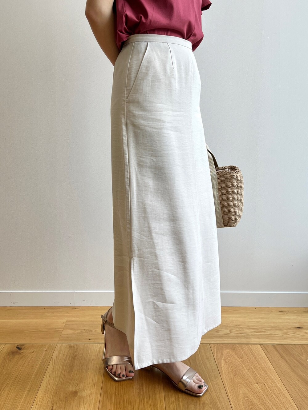 レッド系のTシャツ/カットソー、ゴールド系のサンダル、ベージュ系のスカートを着用したレディースの春コーディネートの6枚目の写真