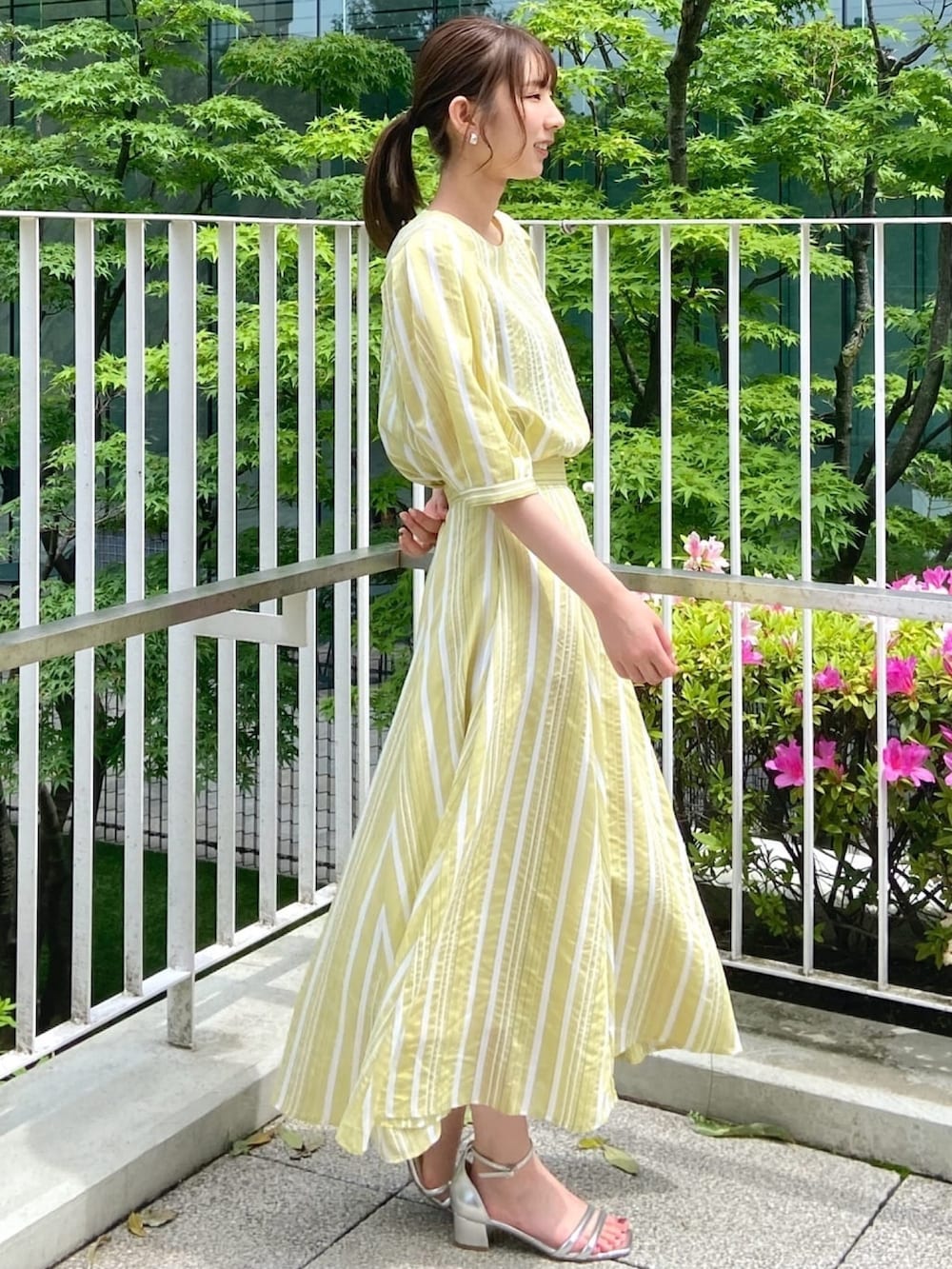 イエロー系のシャツ/ブラウス、イエロー系のスカート、シルバー系のサンダルを着用したレディースの春コーディネートの5枚目の写真