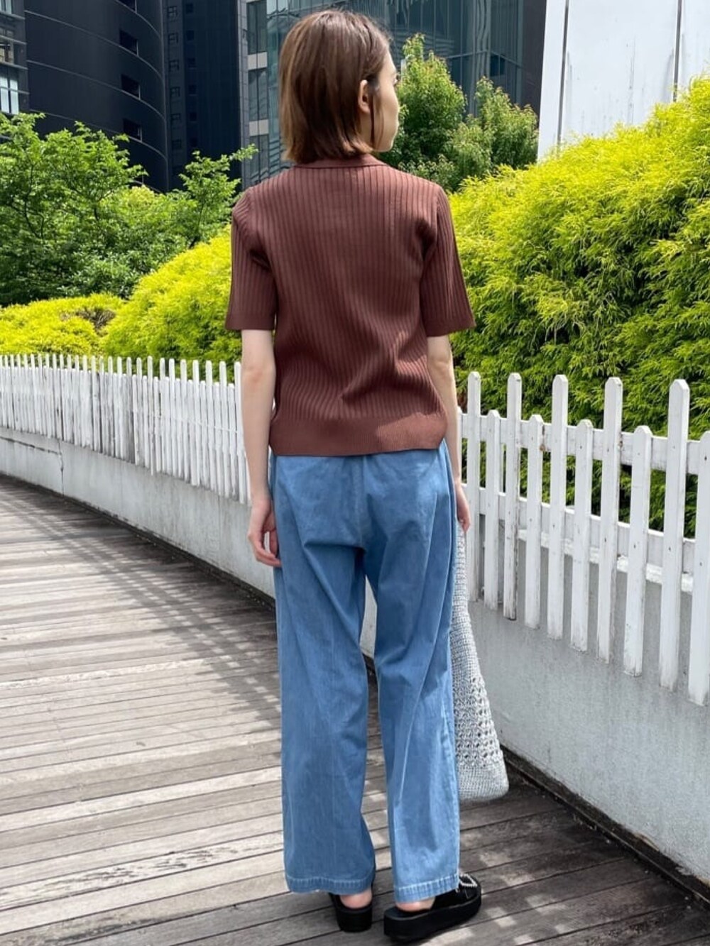 ブラウン系のニット/セーター、ブルー系のデニムパンツ、シルバー系のトートバッグを着用したレディースの春コーディネートの6枚目の写真