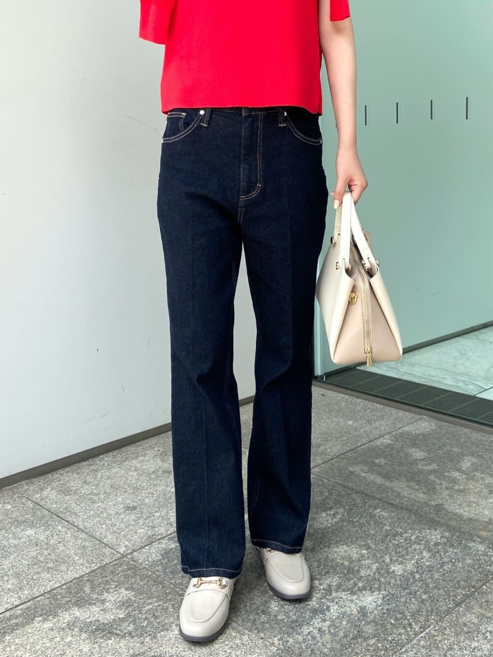 レッド系のカーディガン/ボレロ、レッド系のニット/セーター、ブルー系のデニムパンツを着用したレディースの夏コーディネートの7枚目の写真