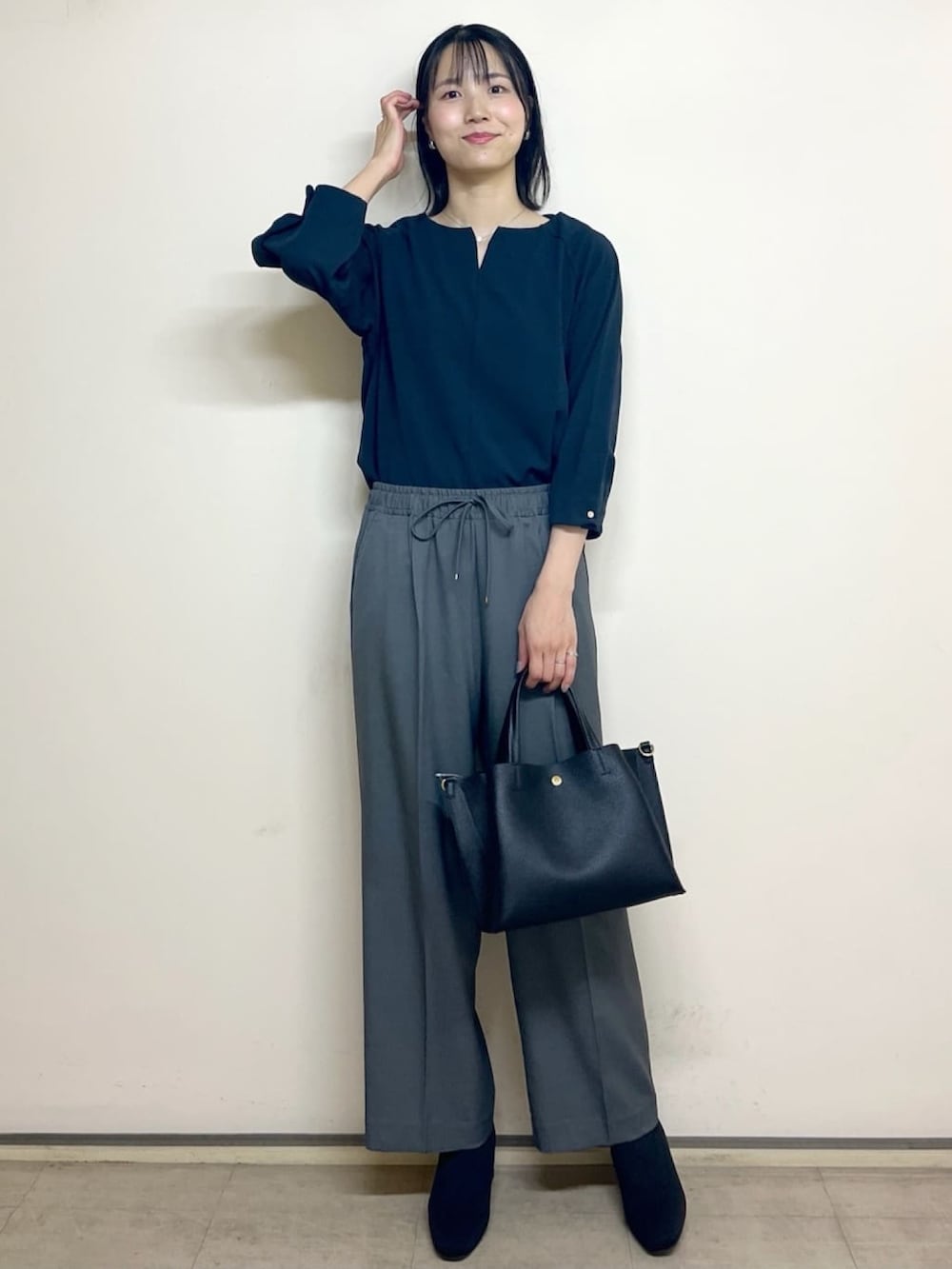 ブルー系のTシャツ/カットソー、グレー系のその他パンツ、ブラック系のトートバッグを着用したレディースの秋コーディネートの2枚目の写真