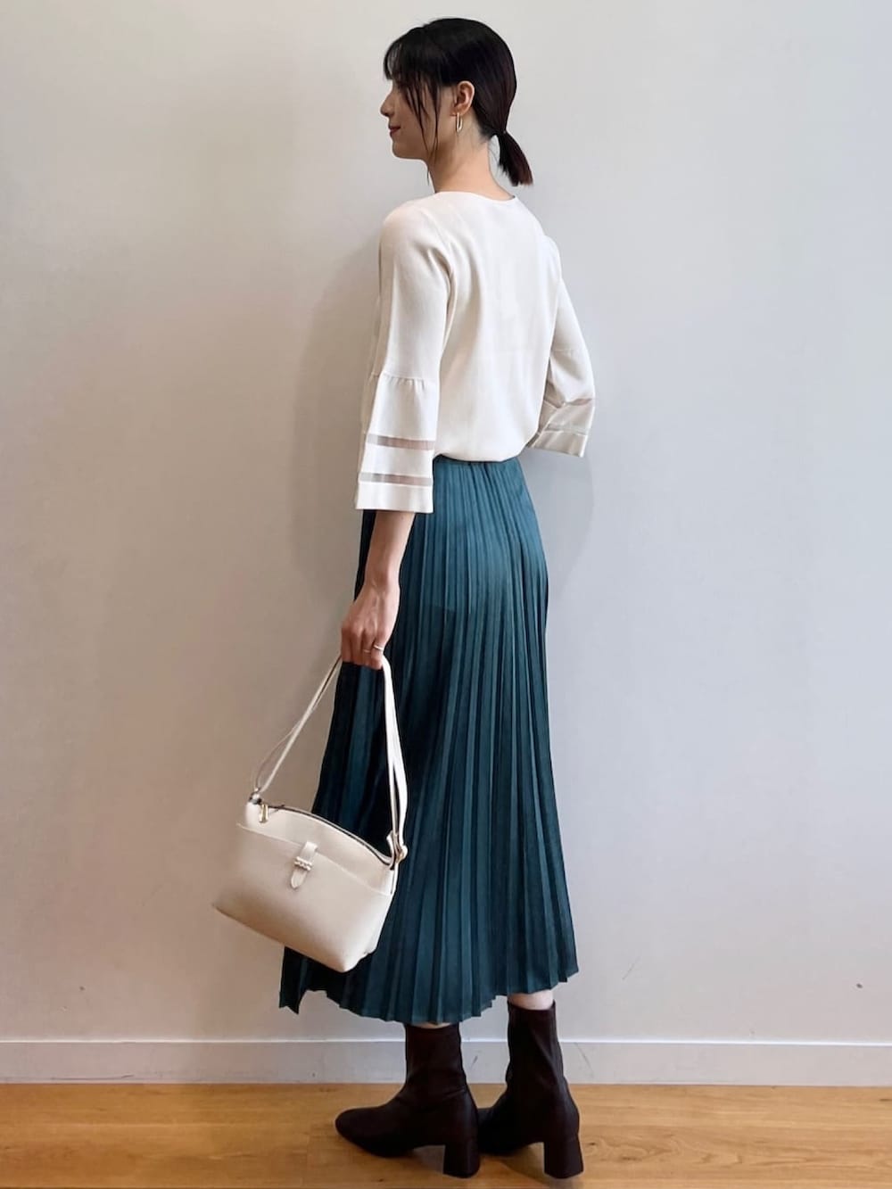 ブラウン系のブーツ、ホワイト系のニット/セーター、ブルー系のスカートを着用したレディースの夏コーディネートの4枚目の写真
