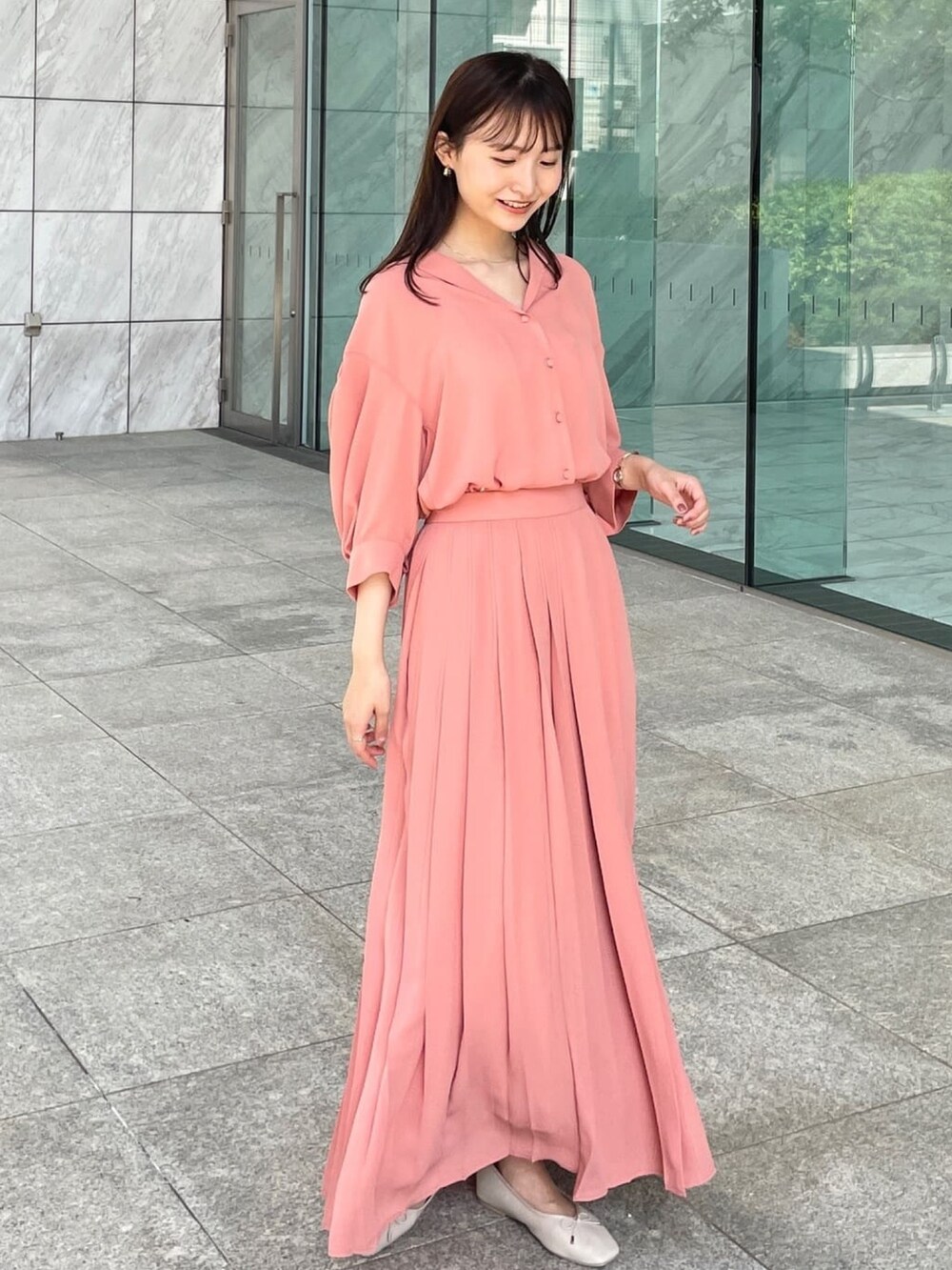 オレンジ系のシャツ/ブラウス、ベージュ系のその他シューズ、オレンジ系のスカートを着用したレディースの春コーディネートの4枚目の写真