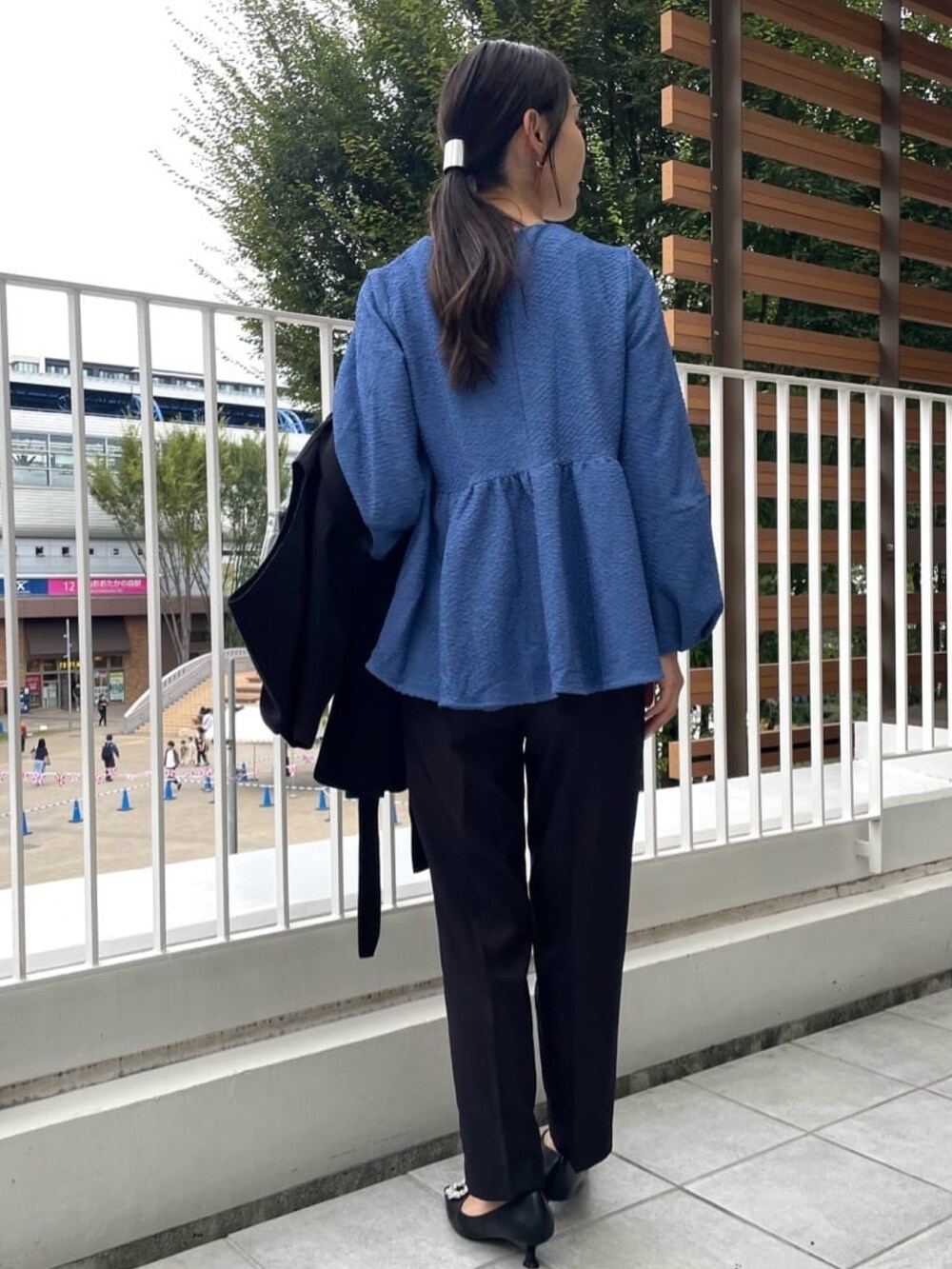 シルバー系のトートバッグ、ブラック系のその他パンツ、ブラック系のパンプスを着用したレディースの秋コーディネートの6枚目の写真