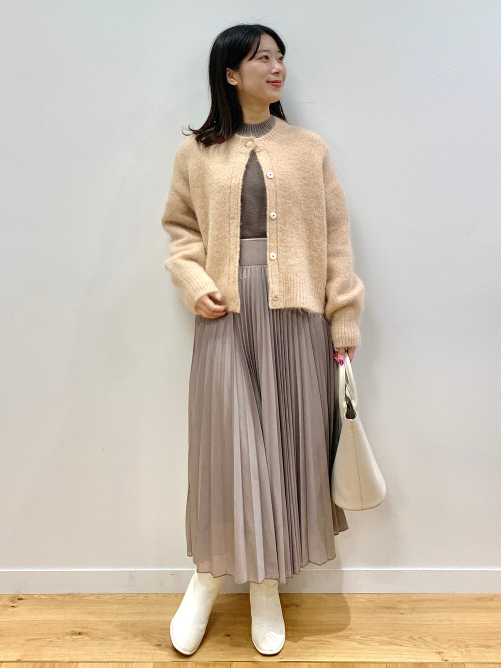 ピンク系のカーディガン/ボレロ、グレー系のワンピース、ホワイト系のトートバッグを着用したレディースの秋コーディネートの2枚目の写真