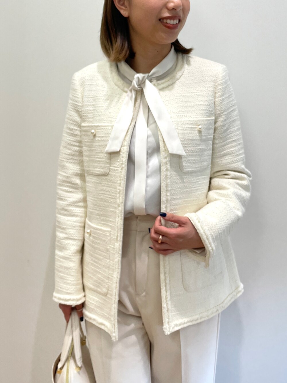 ホワイト系のノーカラージャケット、ホワイト系のシャツ/ブラウス、ベージュ系のその他パンツを着用したレディースの冬コーディネートの4枚目の写真