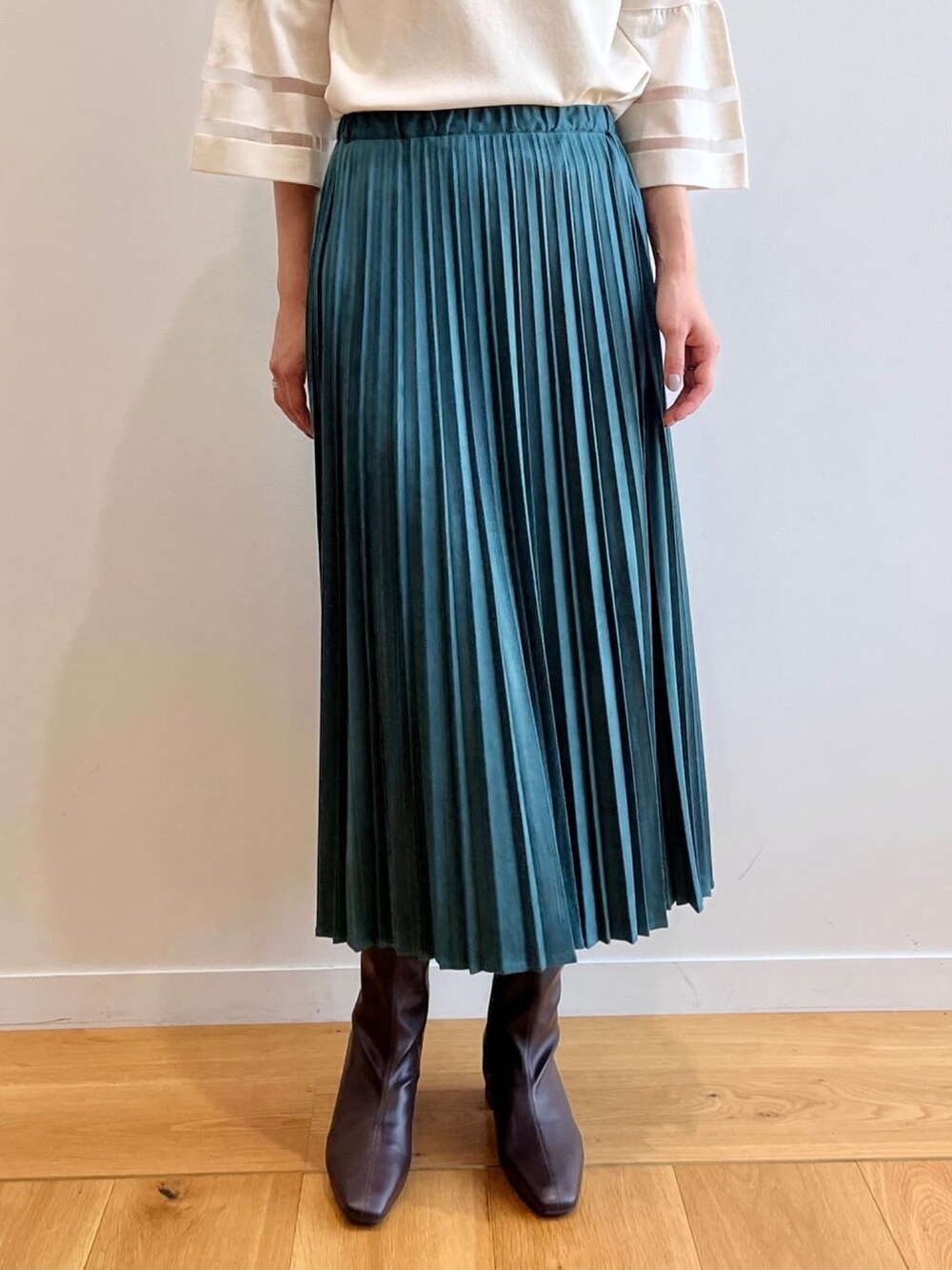 ブラウン系のブーツ、ホワイト系のニット/セーター、ブルー系のスカートを着用したレディースの夏コーディネートの6枚目の写真