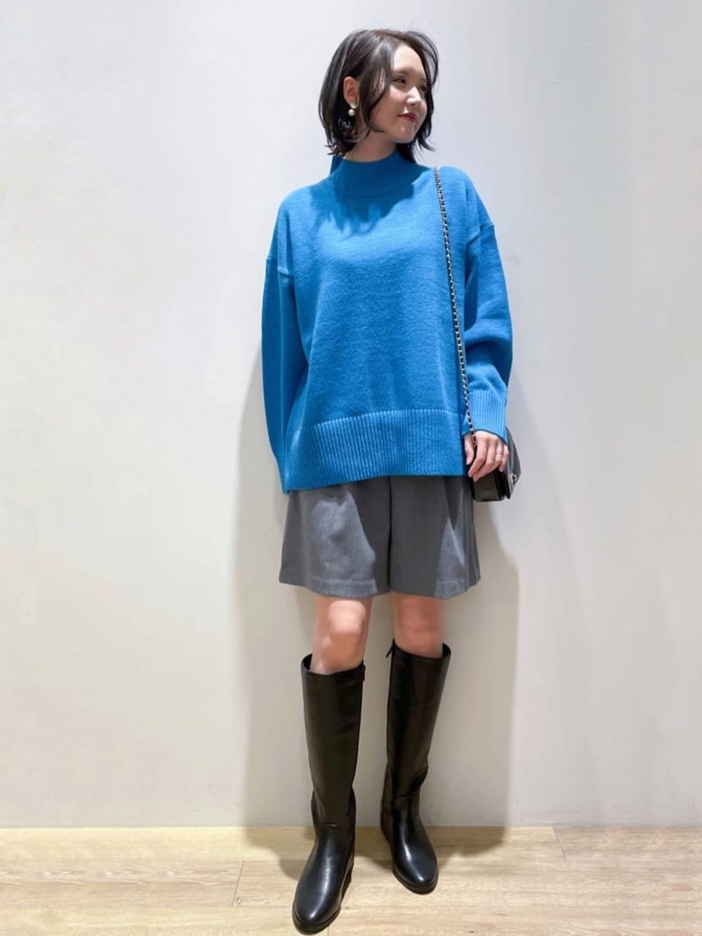 ブルー系のニット/セーター、グレー系のその他パンツ、ブラック系のブーツを着用したレディースの冬コーディネートの5枚目の写真