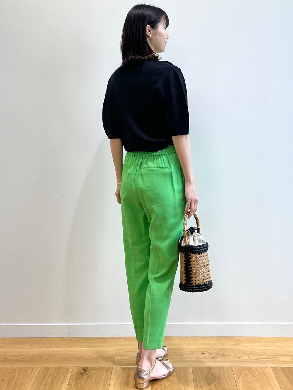 ブラック系のニット/セーター、ゴールド系のサンダル、ブラック系のトートバッグを着用したレディースの春コーディネートの3枚目の写真