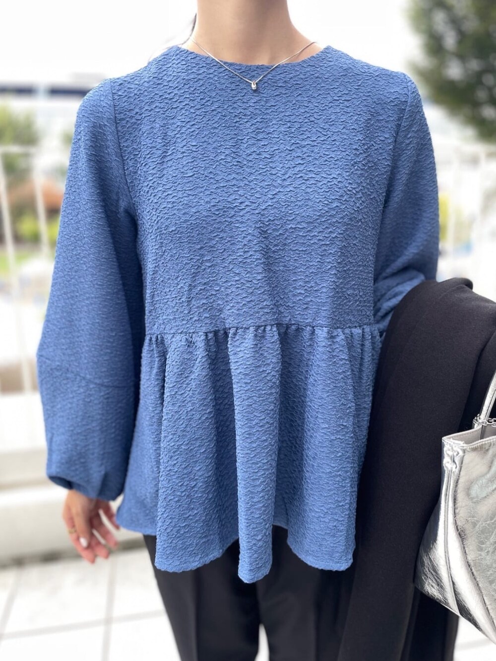 シルバー系のトートバッグ、ブラック系のその他パンツ、ブラック系のパンプスを着用したレディースの秋コーディネートの7枚目の写真