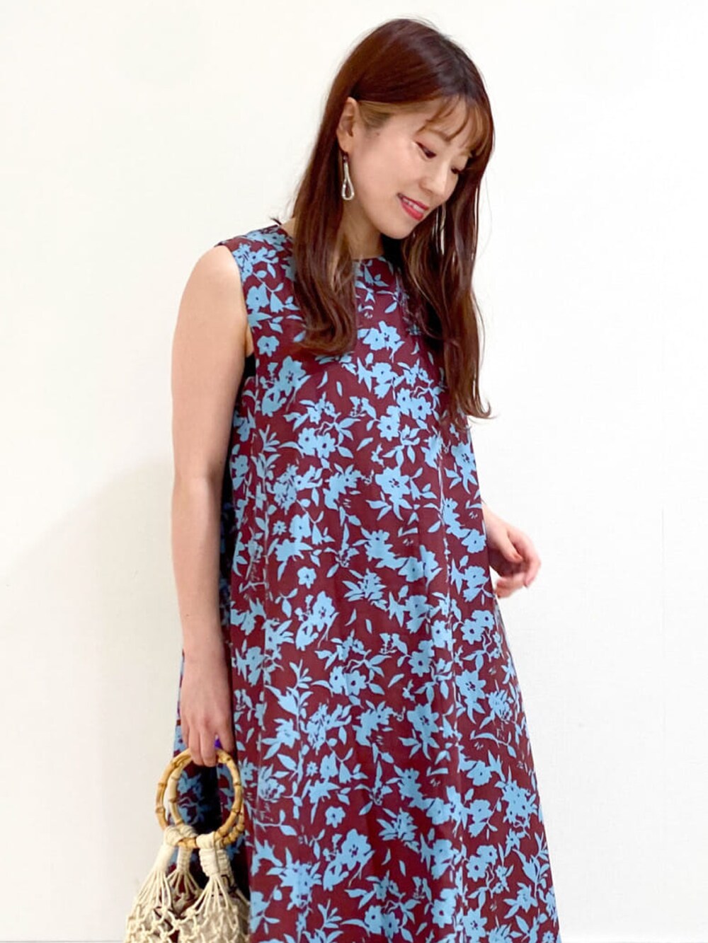 レッド系のワンピース、ベージュ系のハンドバッグ、ホワイト系のサンダルを着用したレディースの夏コーディネートの4枚目の写真