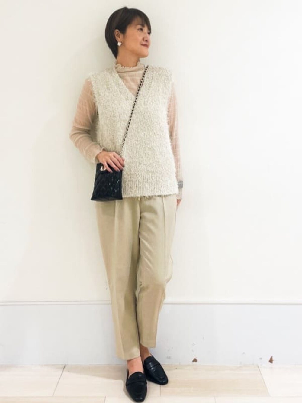 ブラック系のその他シューズ、ブラック系のショルダーバッグ、ベージュ系のTシャツ/カットソーを着用したレディースの春コーディネートの4枚目の写真