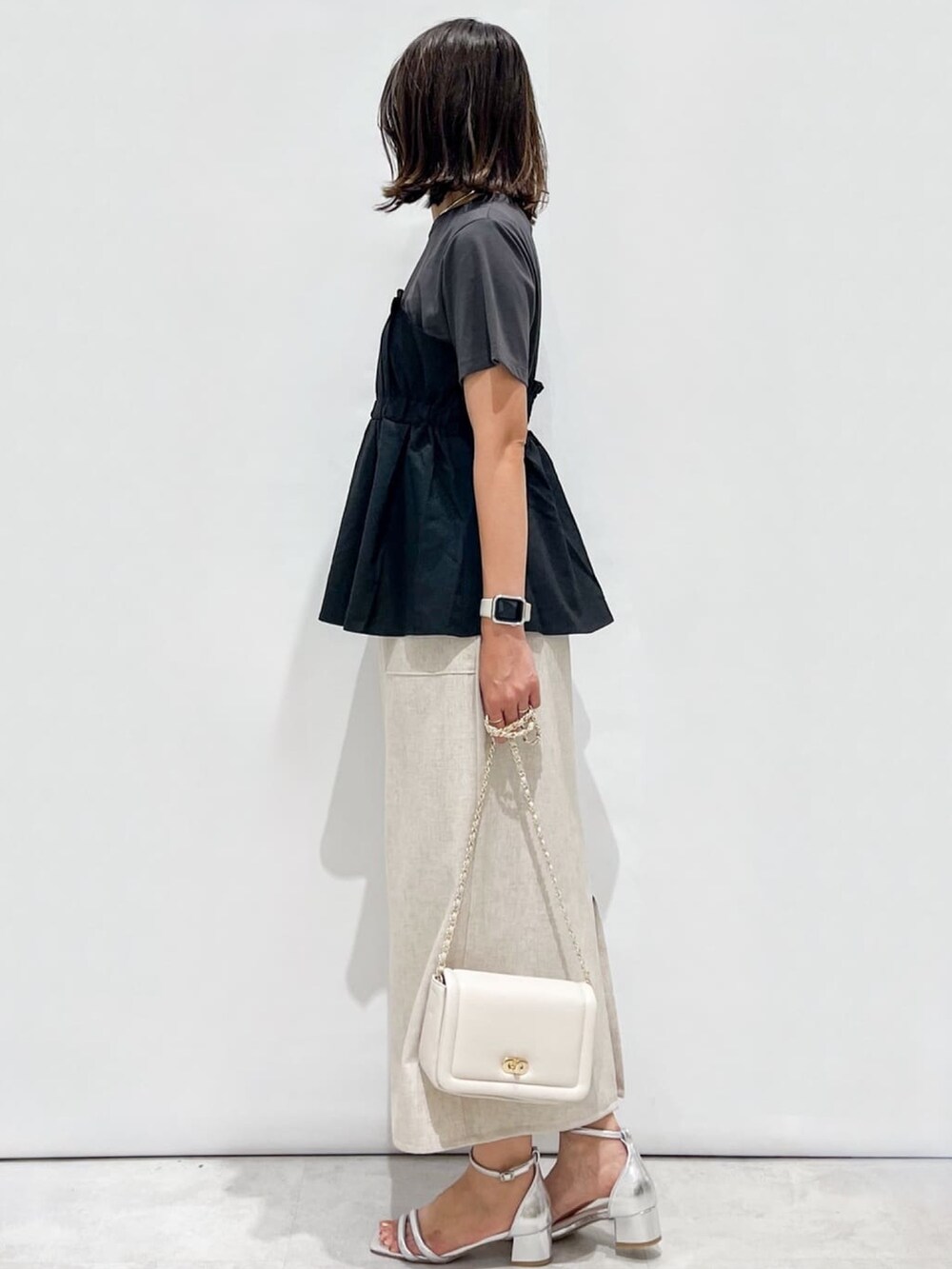 ブラック系のTシャツ/カットソー、ベージュ系のスカート、ホワイト系のショルダーバッグを着用したレディースの夏コーディネートの6枚目の写真