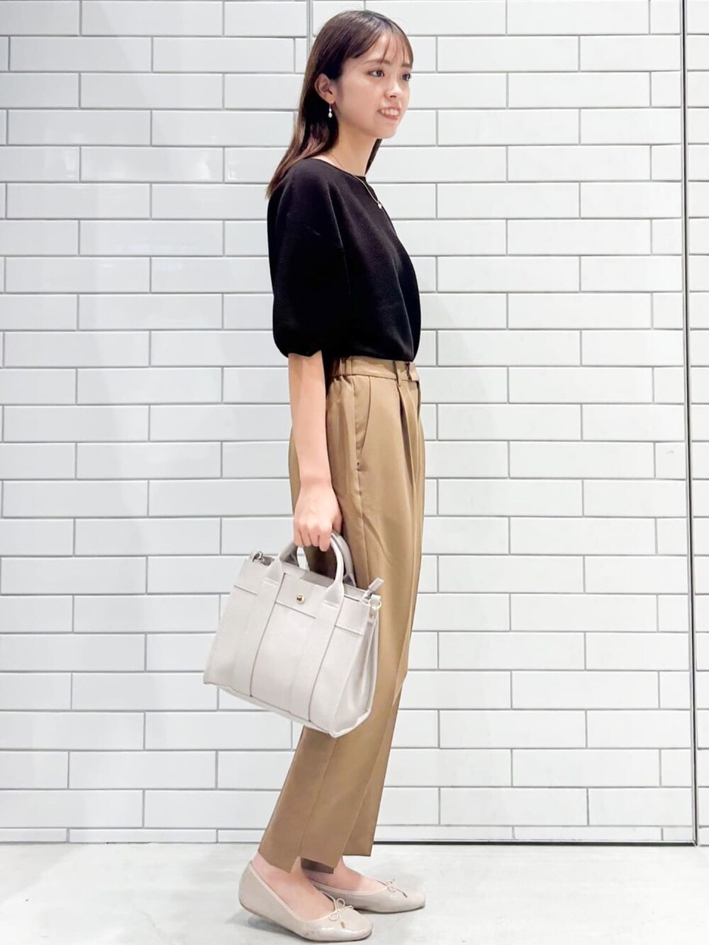 ブラウン系のニット/セーター、ブラウン系のその他パンツ、ホワイト系のトートバッグを着用したレディースの秋コーディネートの2枚目の写真