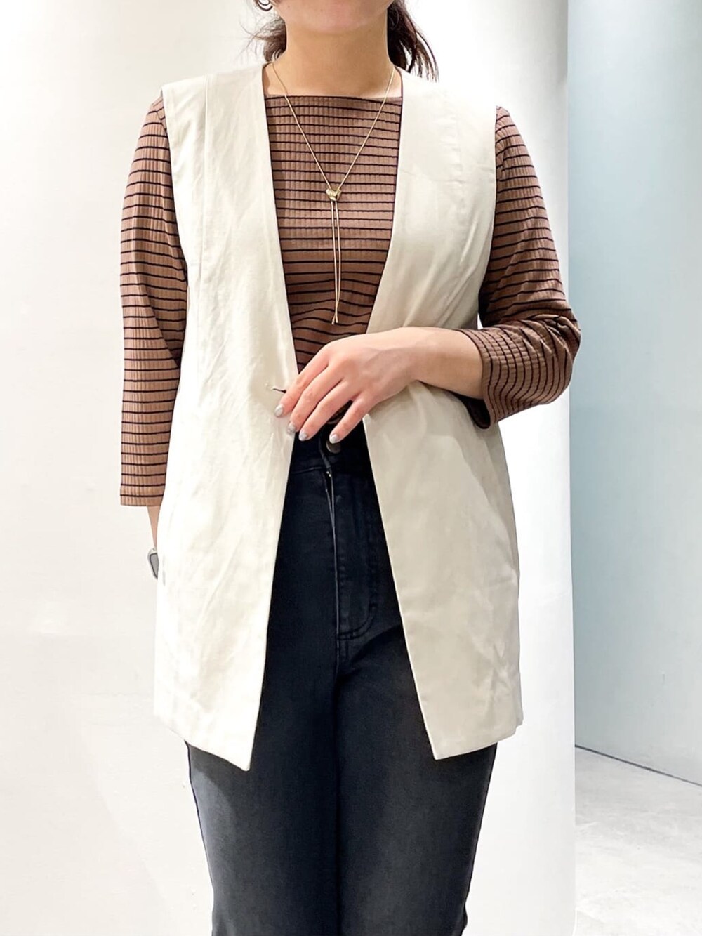 ブラック系のドレスシューズ、ブラック系のデニムパンツ、ホワイト系のベストを着用したレディースの夏コーディネートの7枚目の写真