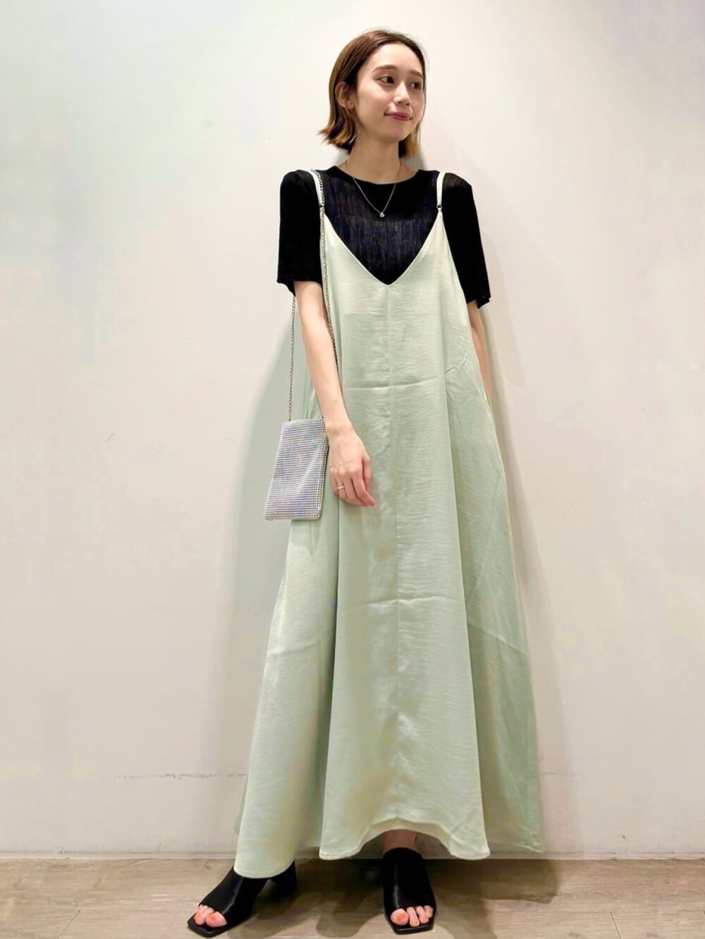 ブラック系のニット/セーター、グリーン系のワンピース、シルバー系のショルダーバッグを着用したレディースの夏コーディネートの6枚目の写真