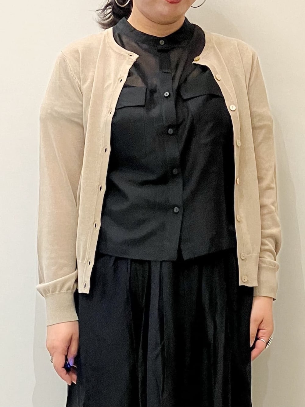 ベージュ系のカーディガン/ボレロ、ブラック系のシャツ/ブラウス、ブラック系のスカートを着用したレディースの春コーディネートの6枚目の写真