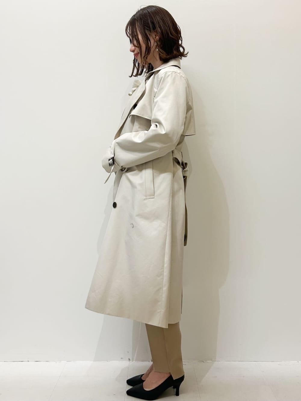 ベージュ系のその他パンツ、ホワイト系のシャツ/ブラウス、ベージュ系のトレンチコートを着用したレディースの冬コーディネートの2枚目の写真