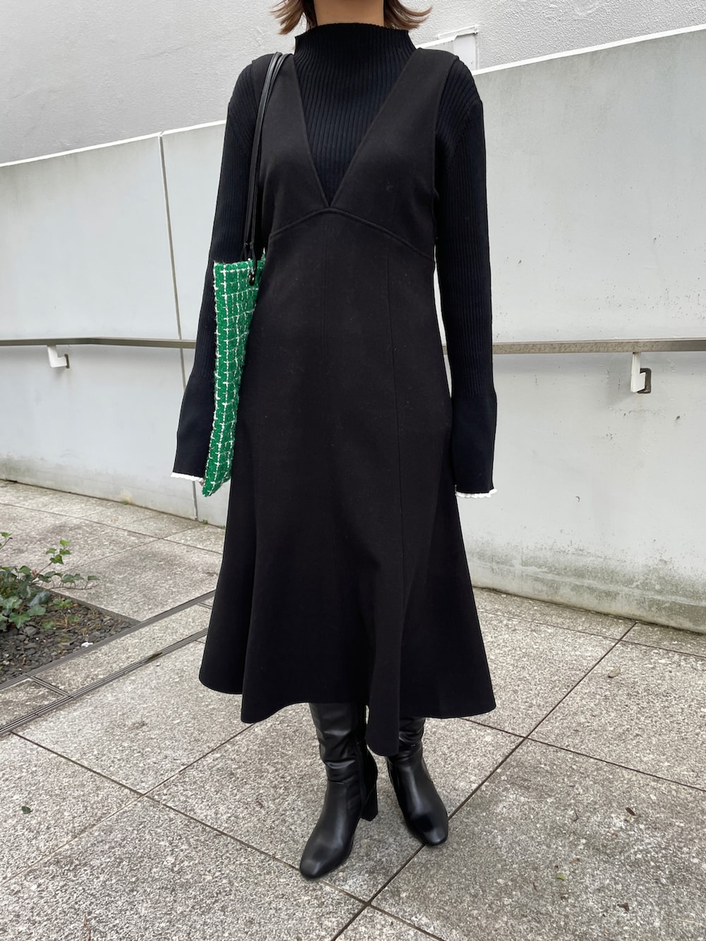 ブラック系のニット/セーター、ブラック系のスカート、グリーン系のトートバッグを着用したレディースの冬コーディネートの4枚目の写真