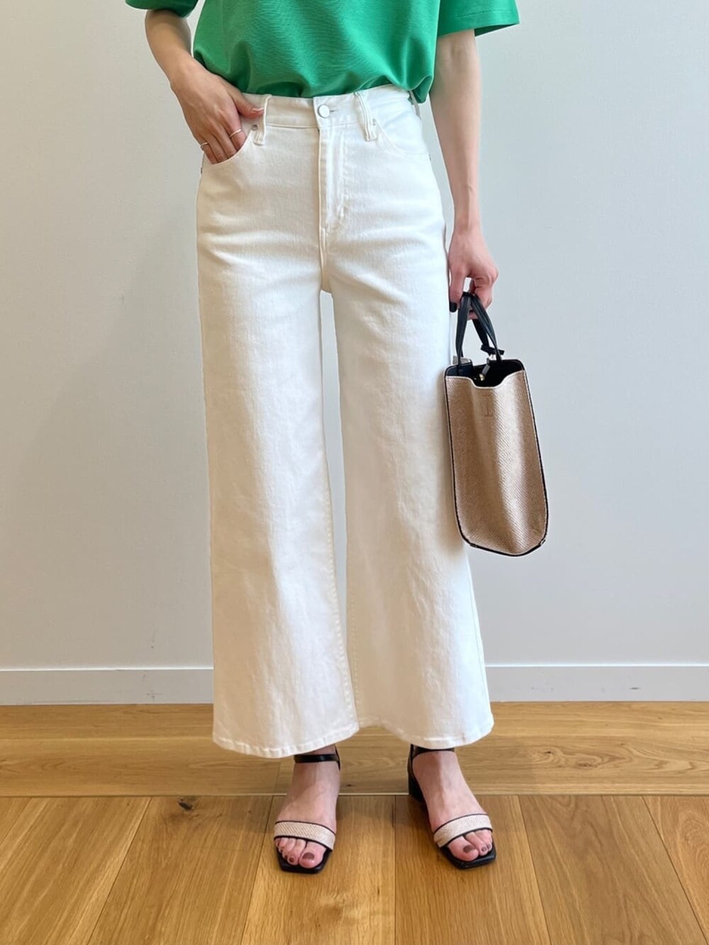 グリーン系のTシャツ/カットソー、ホワイト系のデニムパンツ、ブラック系のサンダルを着用したレディースの夏コーディネートの5枚目の写真