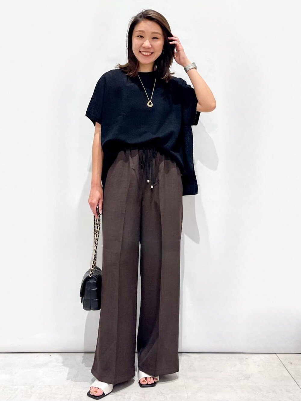 ブラウン系のその他パンツ、ホワイト系のサンダル、ブラック系のショルダーバッグを着用したレディースの夏コーディネートの4枚目の写真