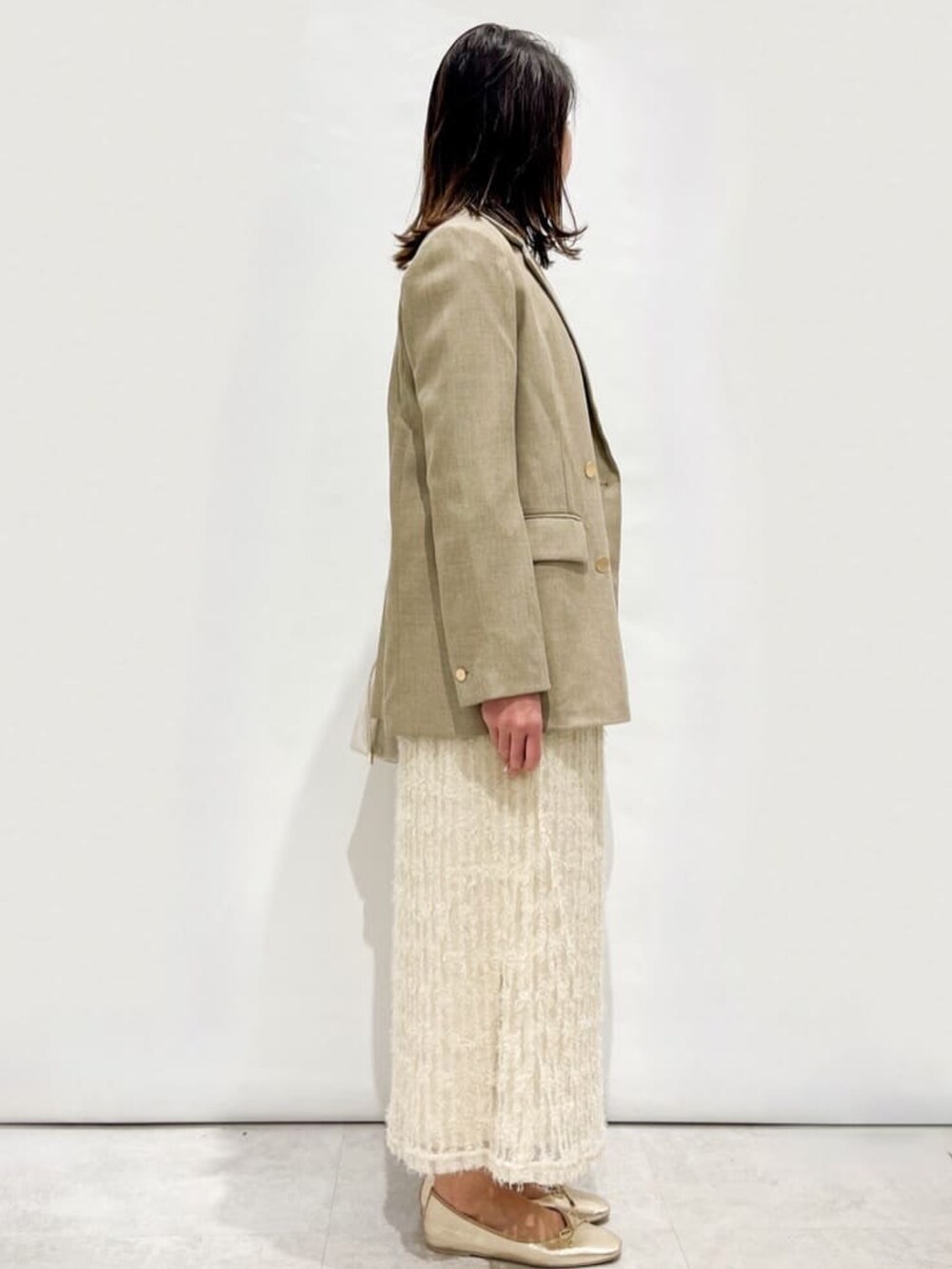 ベージュ系のスカート、ピンク系のTシャツ/カットソー、ベージュ系のテーラードジャケットを着用したレディースの冬コーディネートの2枚目の写真