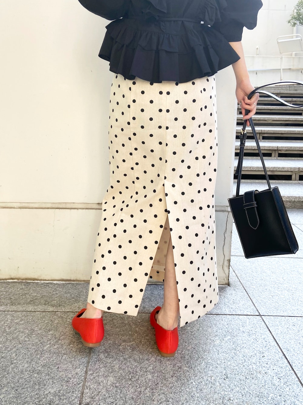 ブラック系のシャツ/ブラウス、ホワイト系のスカート、レッド系のパンプスを着用したレディースの春コーディネートの3枚目の写真